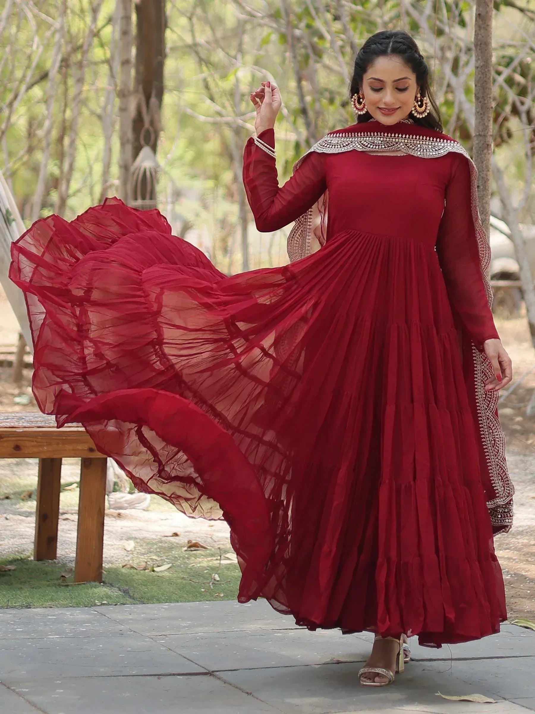 Woman wearing maroon Anarkali dress with dupatta, outdoor ethnic fashion shoot
