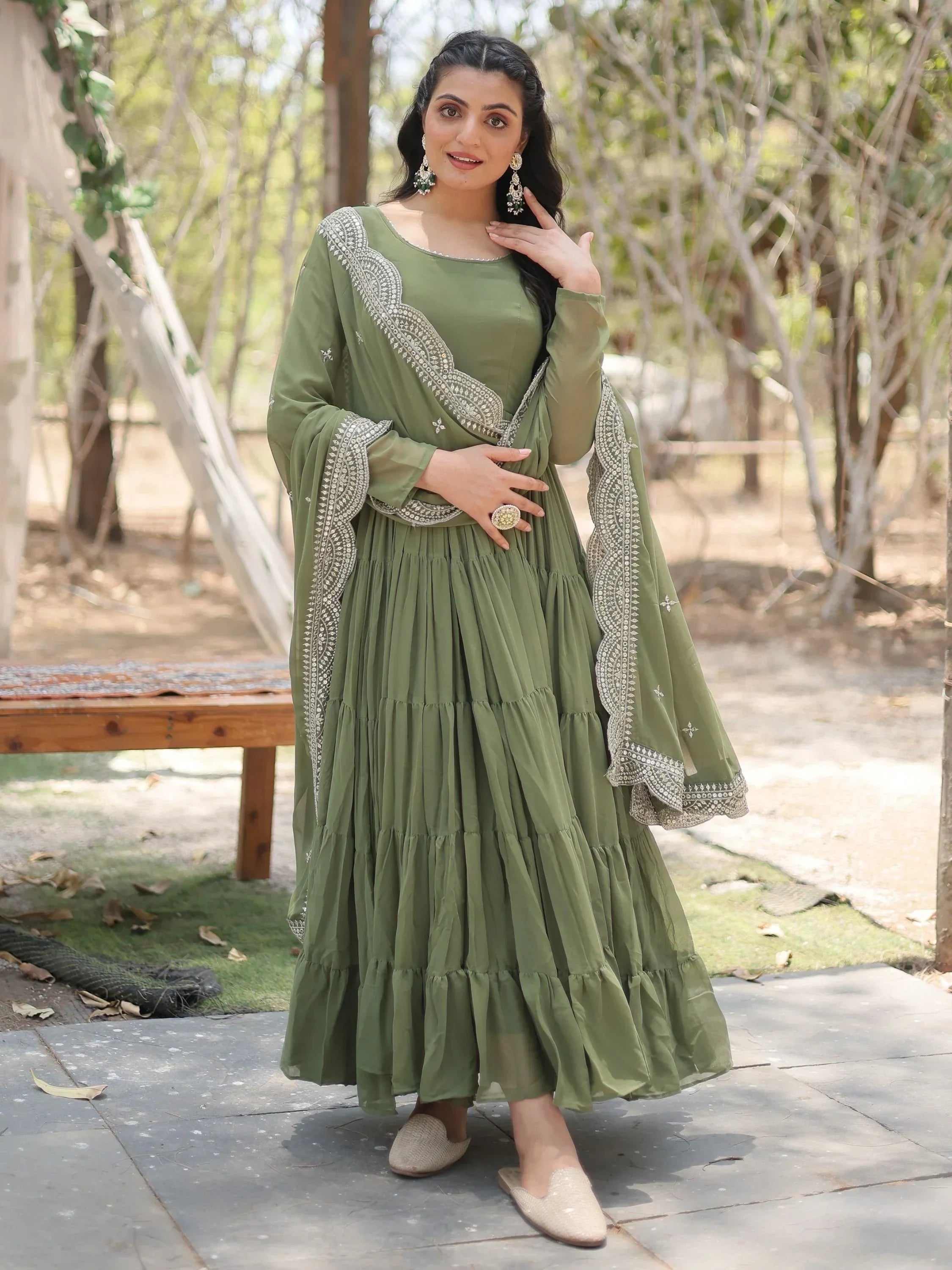 Woman wearing olive green ethnic gown with embroidered dupatta outdoors