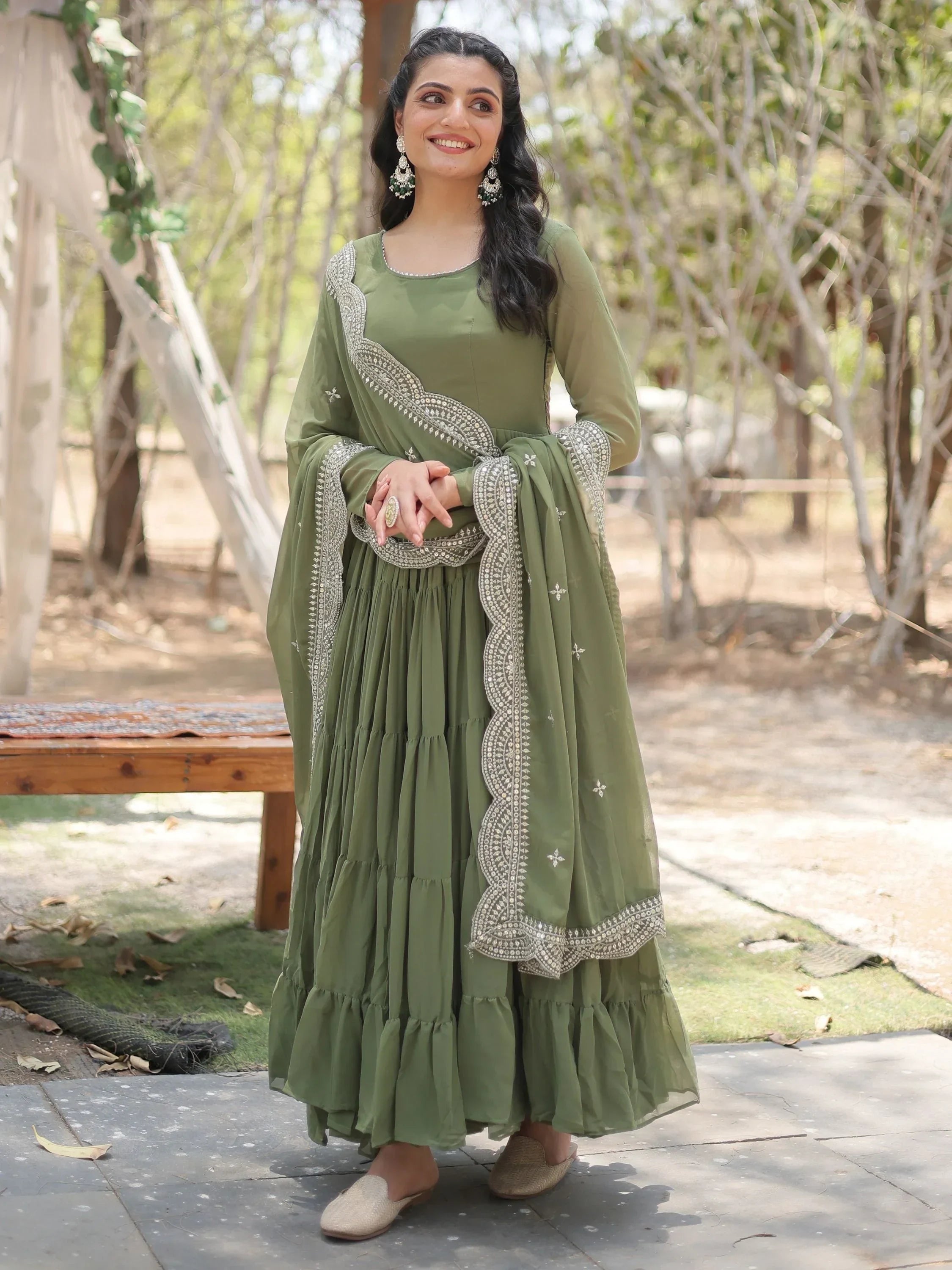 Woman wearing olive green ethnic lehenga with dupatta and silver embroidery outdoors