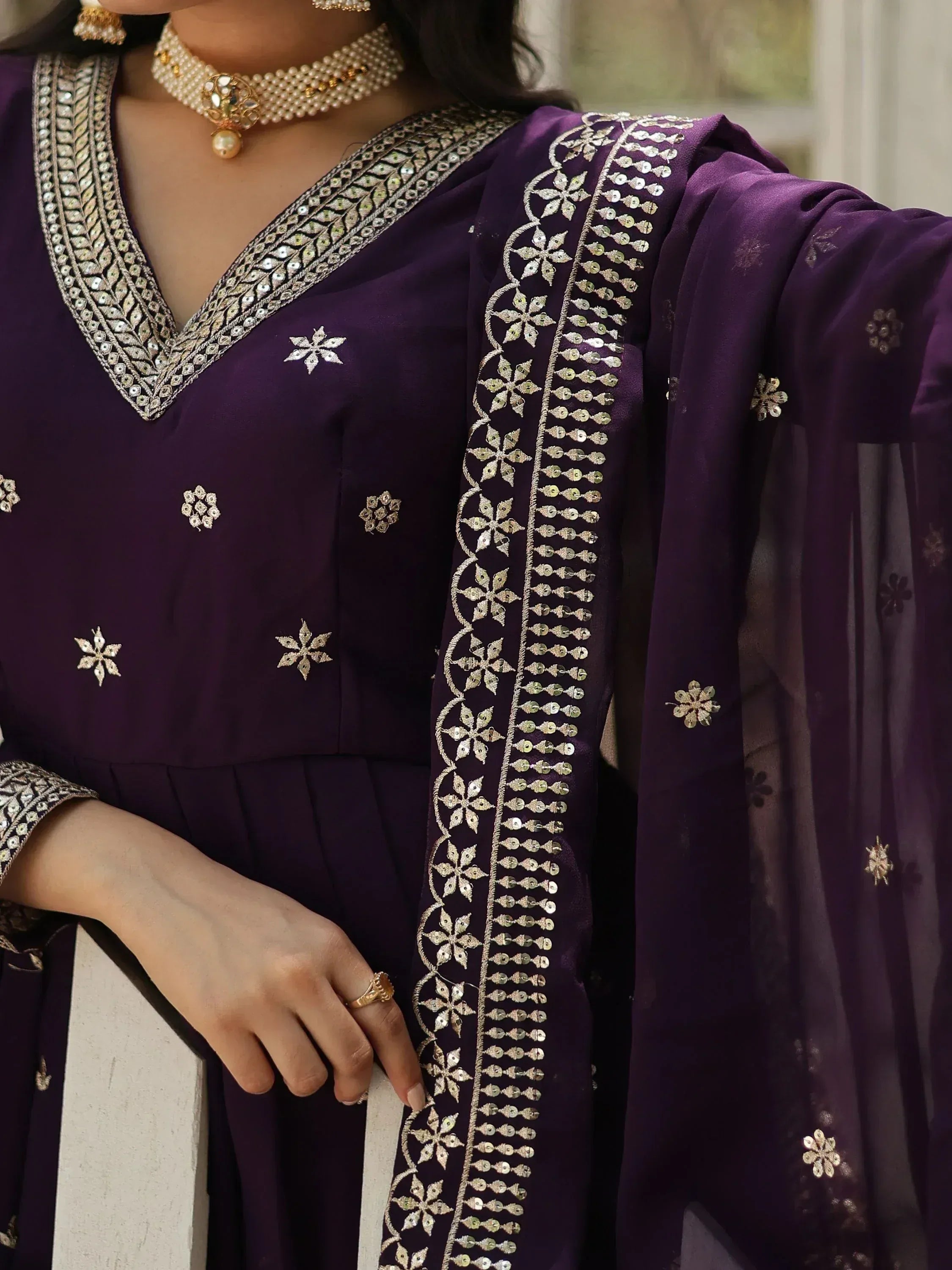 Purple ethnic salwar kameez with gold embroidery and pearl jewelry, perfect for Indian festive occasions.