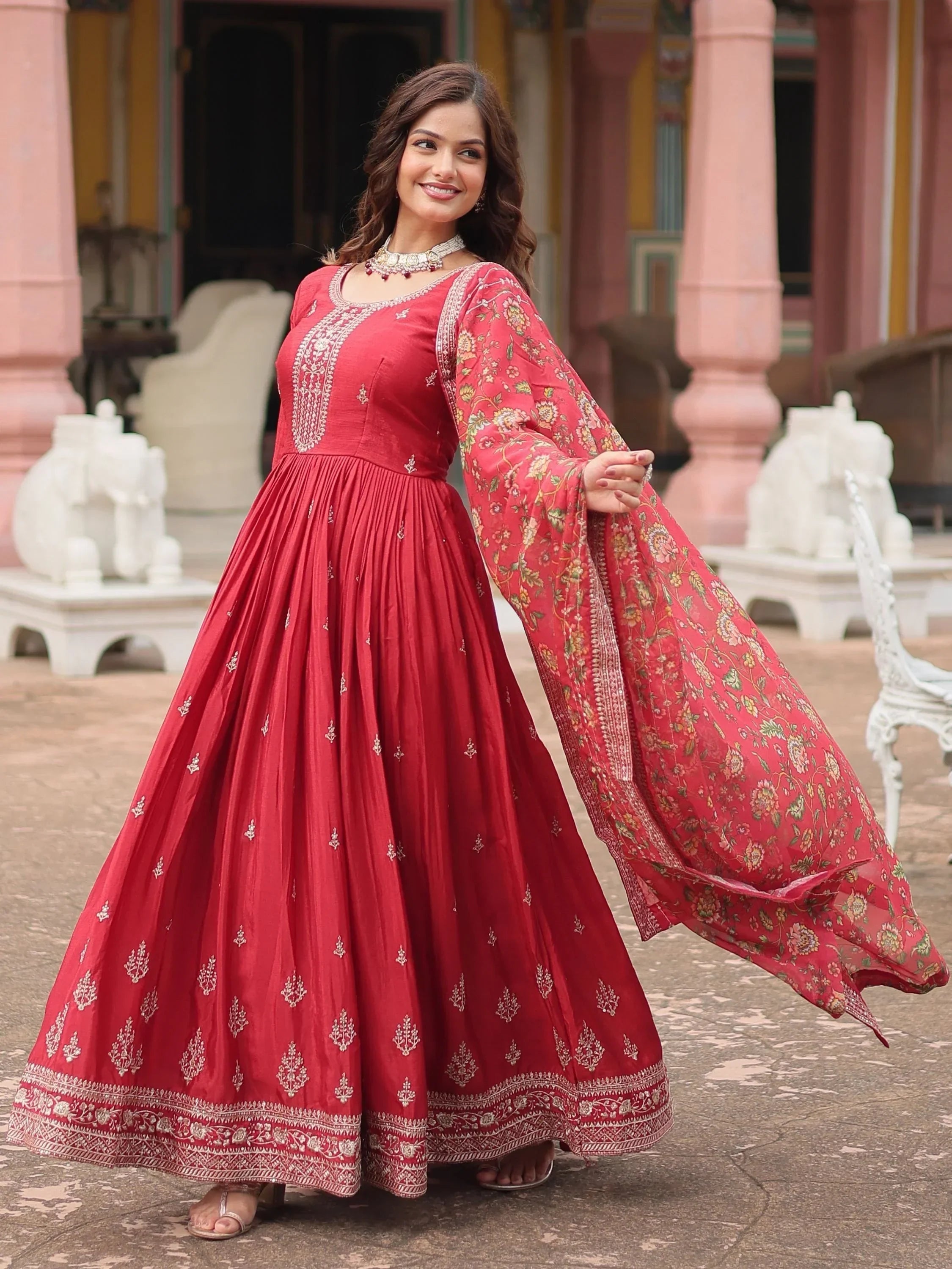 Woman in maroon ethnic gown with embroidered dupatta posing outdoors