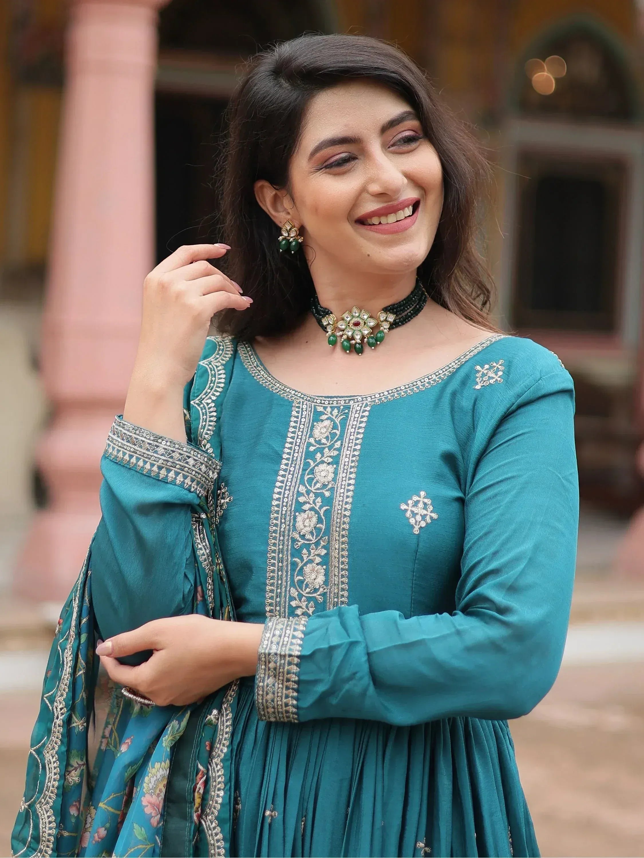 Teal embroidered salwar kameez with floral detailing and traditional jewelry for Indian ethnic wear