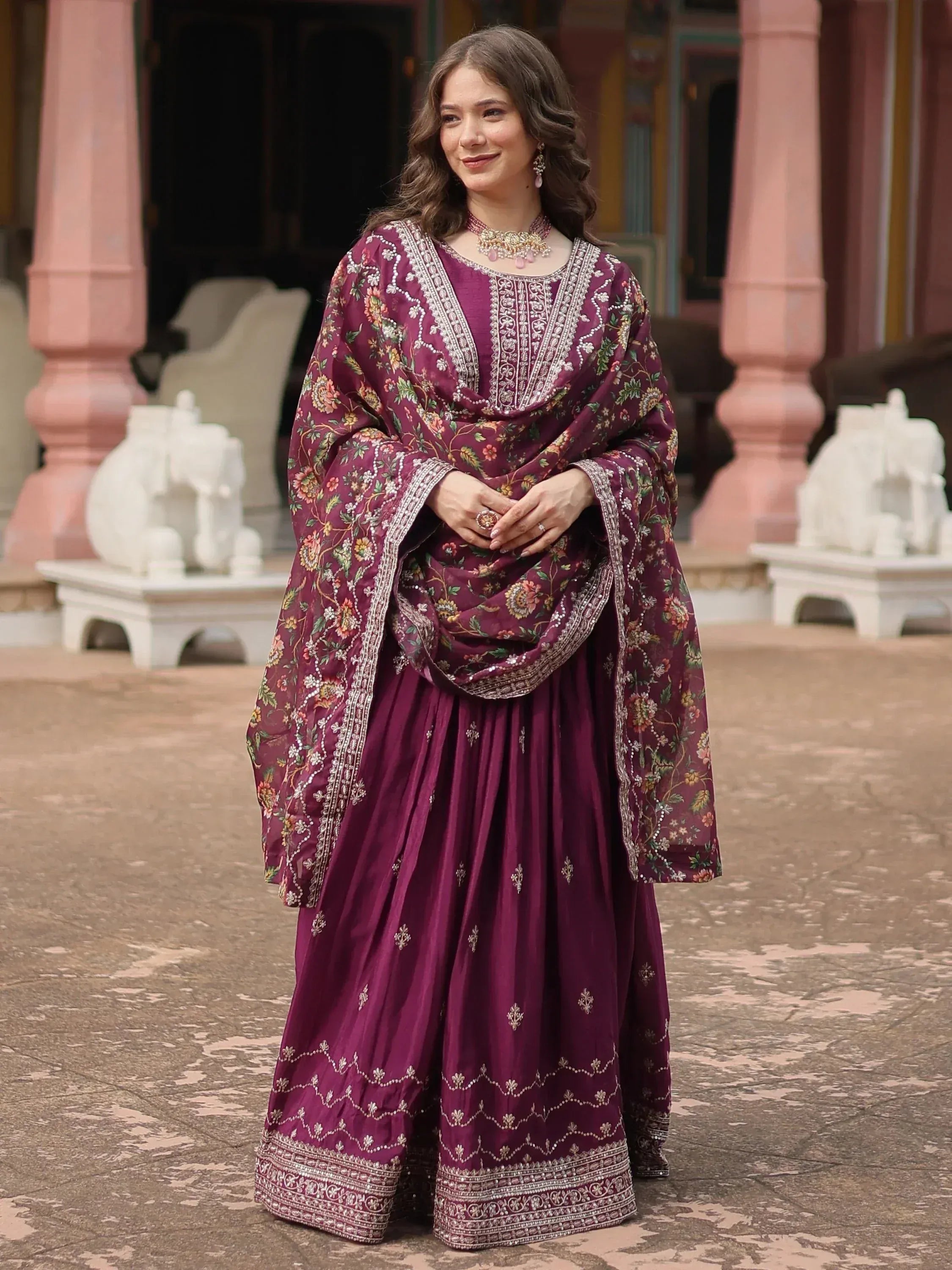 Woman in embroidered wine-colored lehenga choli and dupatta, traditional ethnic wear.