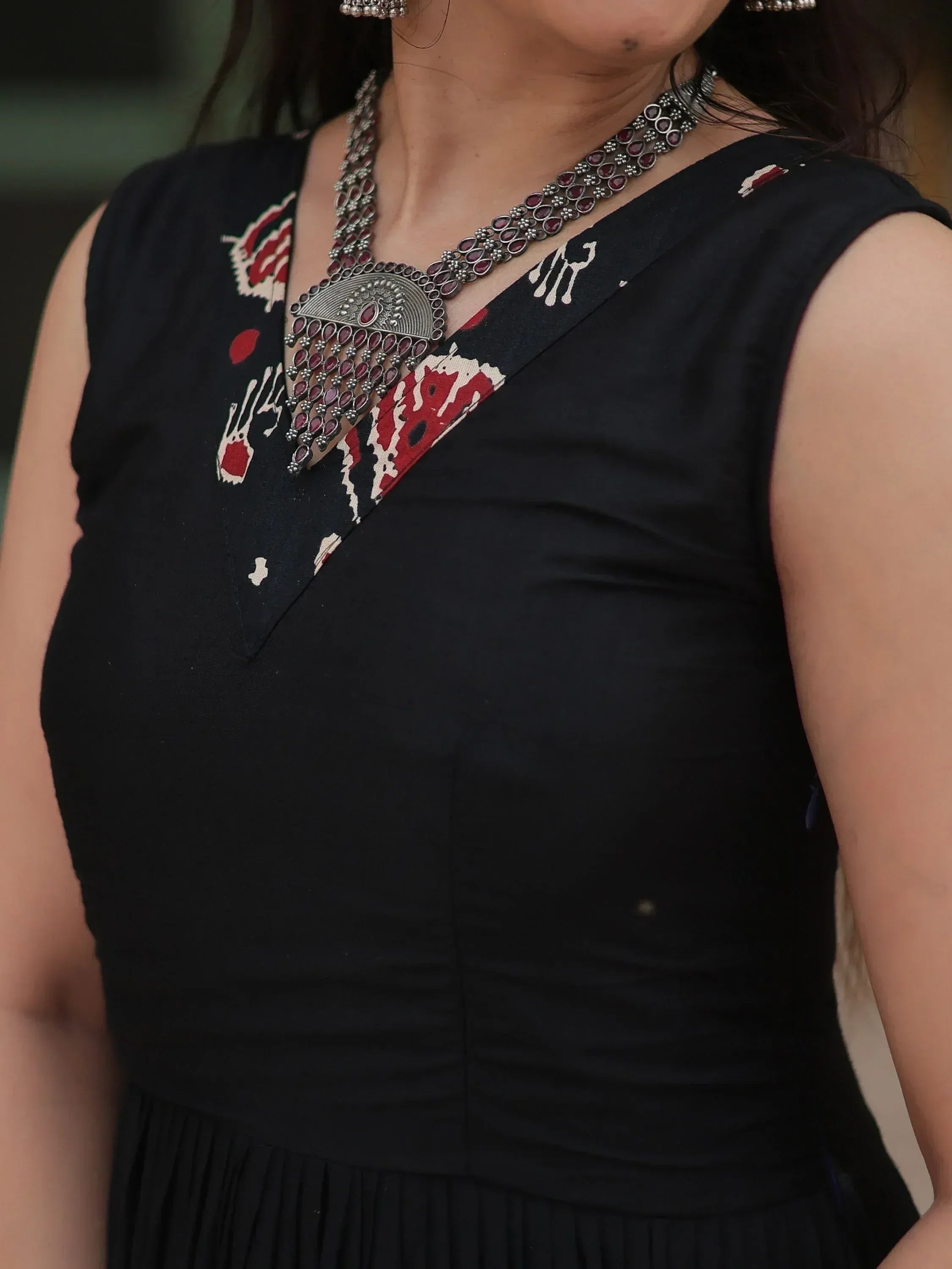 Black ethnic gown with red white print and statement necklace, perfect for Indian occasions