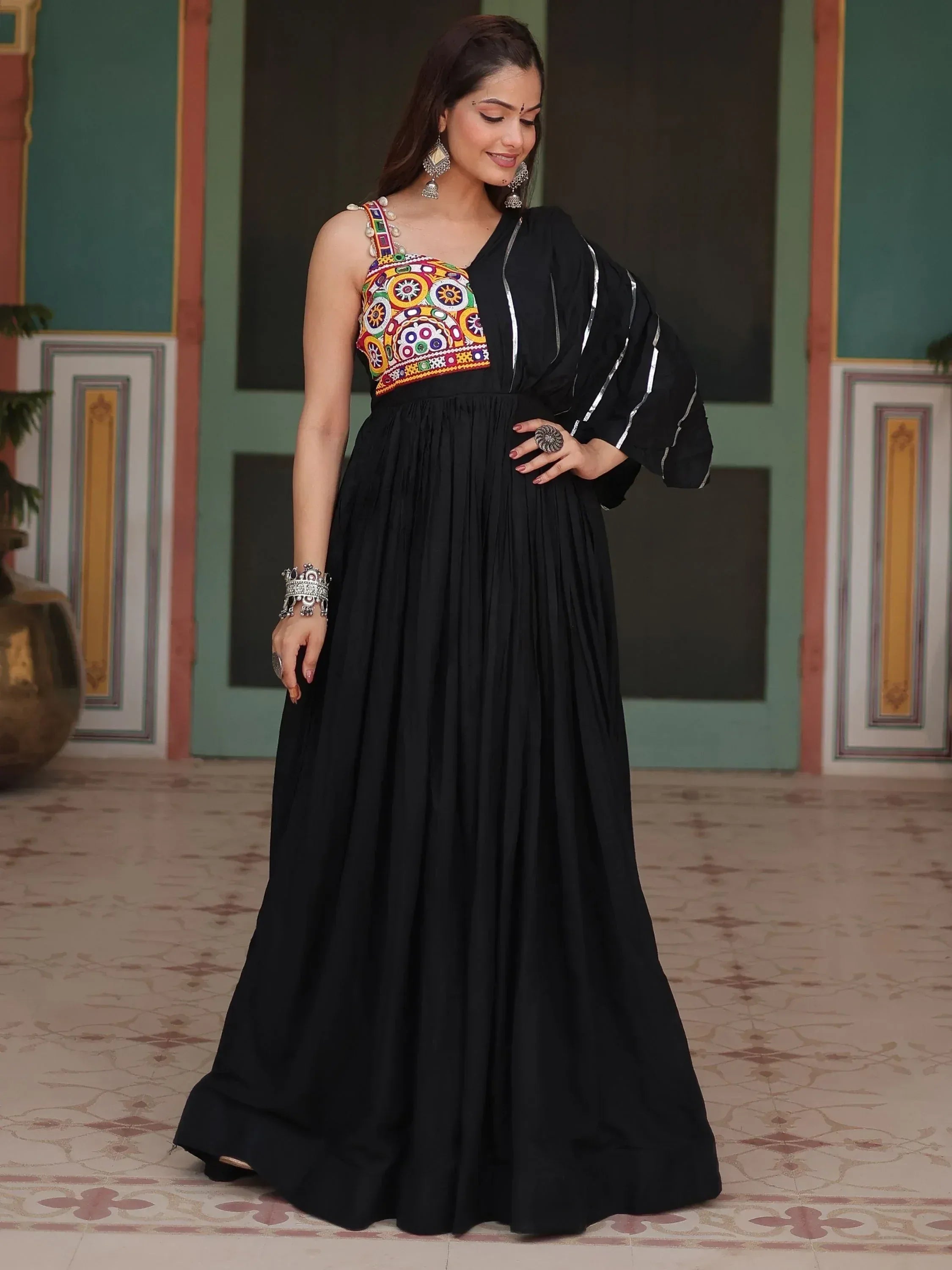 Woman wearing black ethnic gown with colorful embroidered bodice and silver jewelry