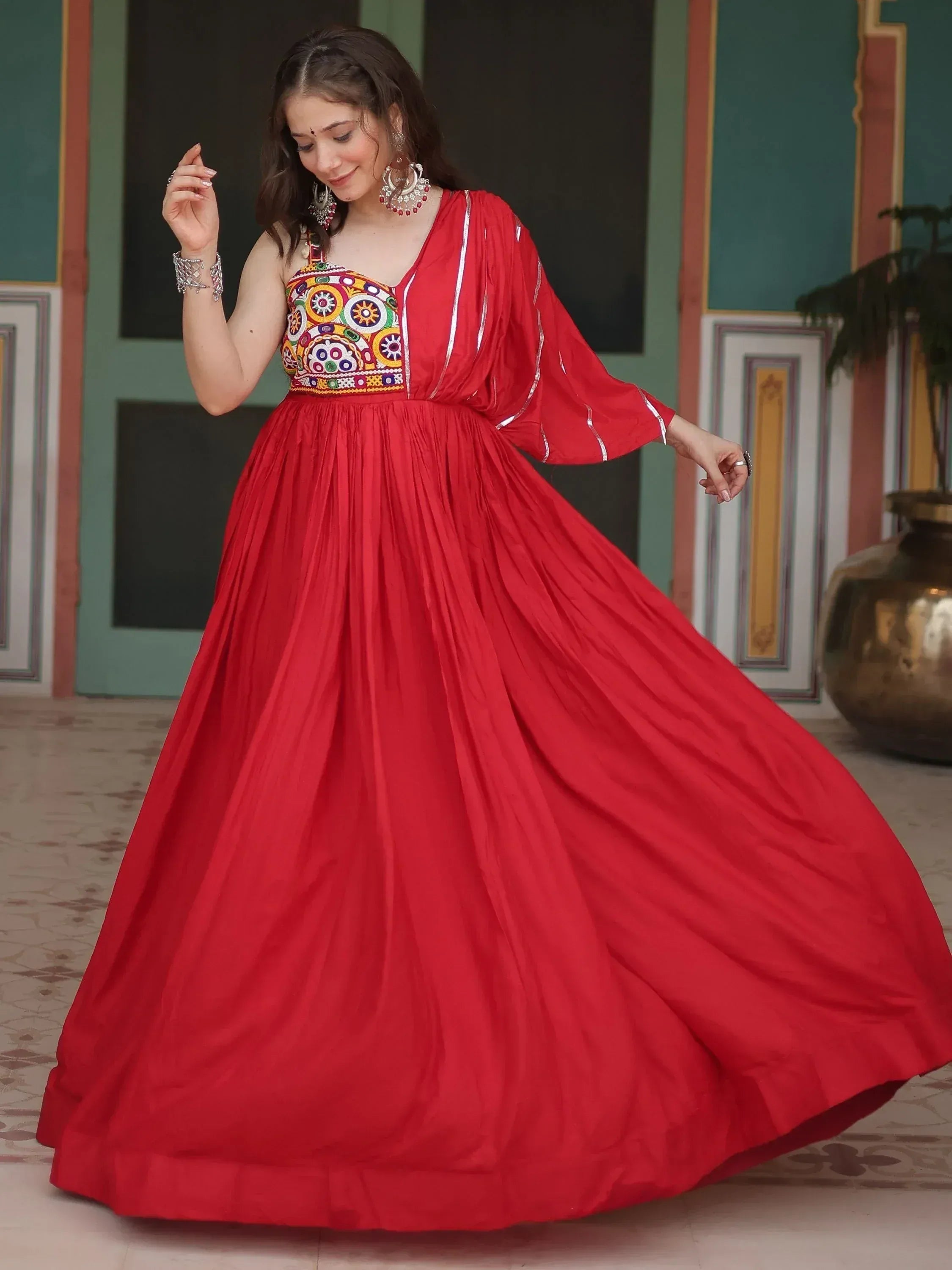 Red ethnic gown with colorful embroidery and flared skirt, perfect for Indian occasions