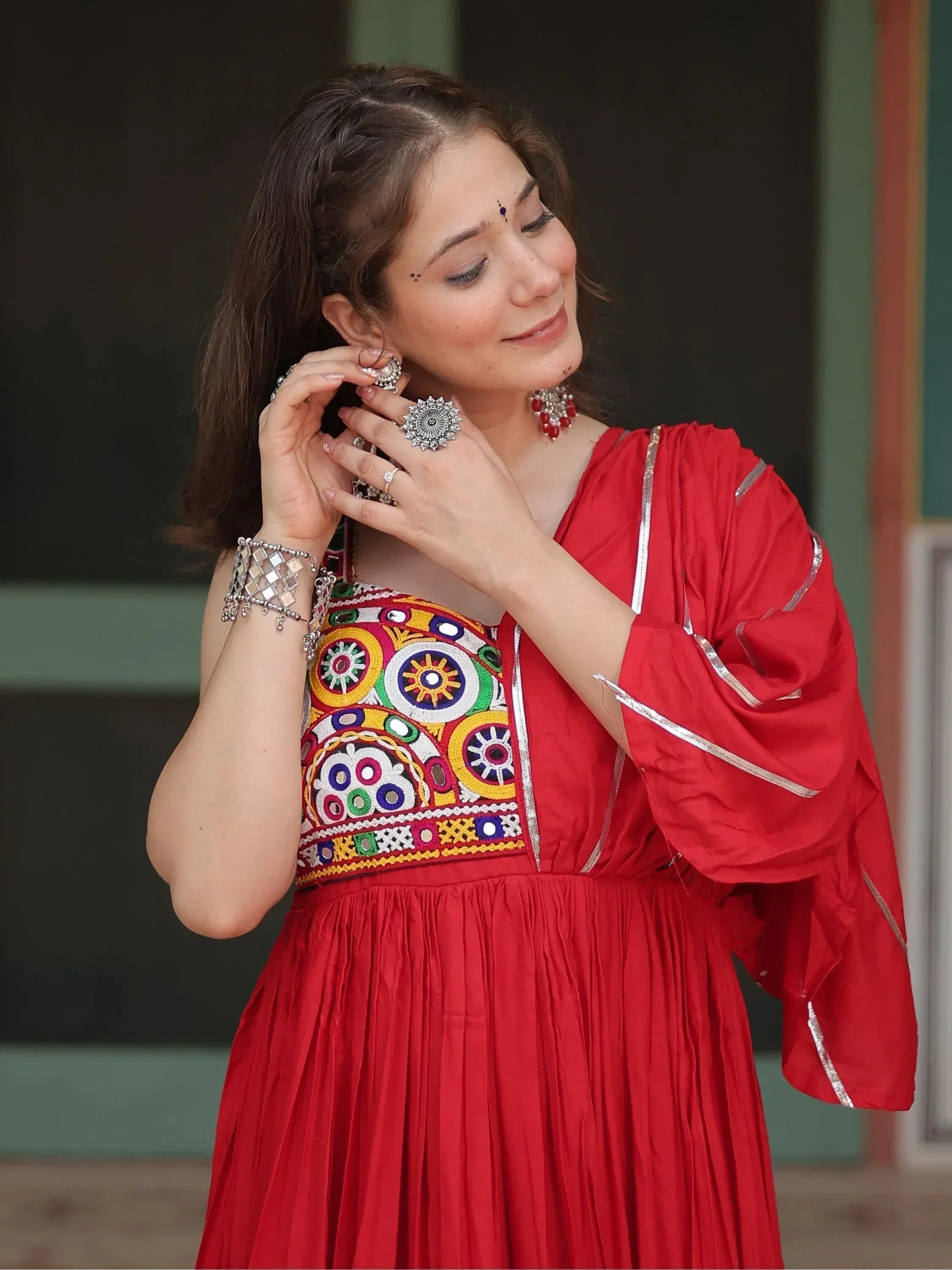 Red ethnic gown with colorful mirror embroidery, perfect for Indian festive occasions and traditional wear.