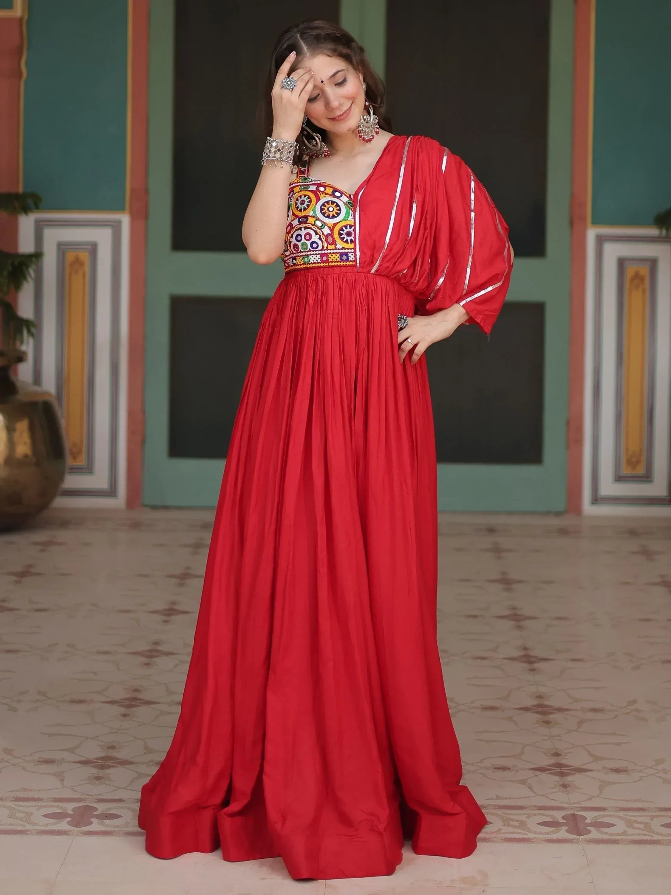 Red ethnic gown with colorful embroidered bodice and puff sleeves, perfect for Indian festive occasions
