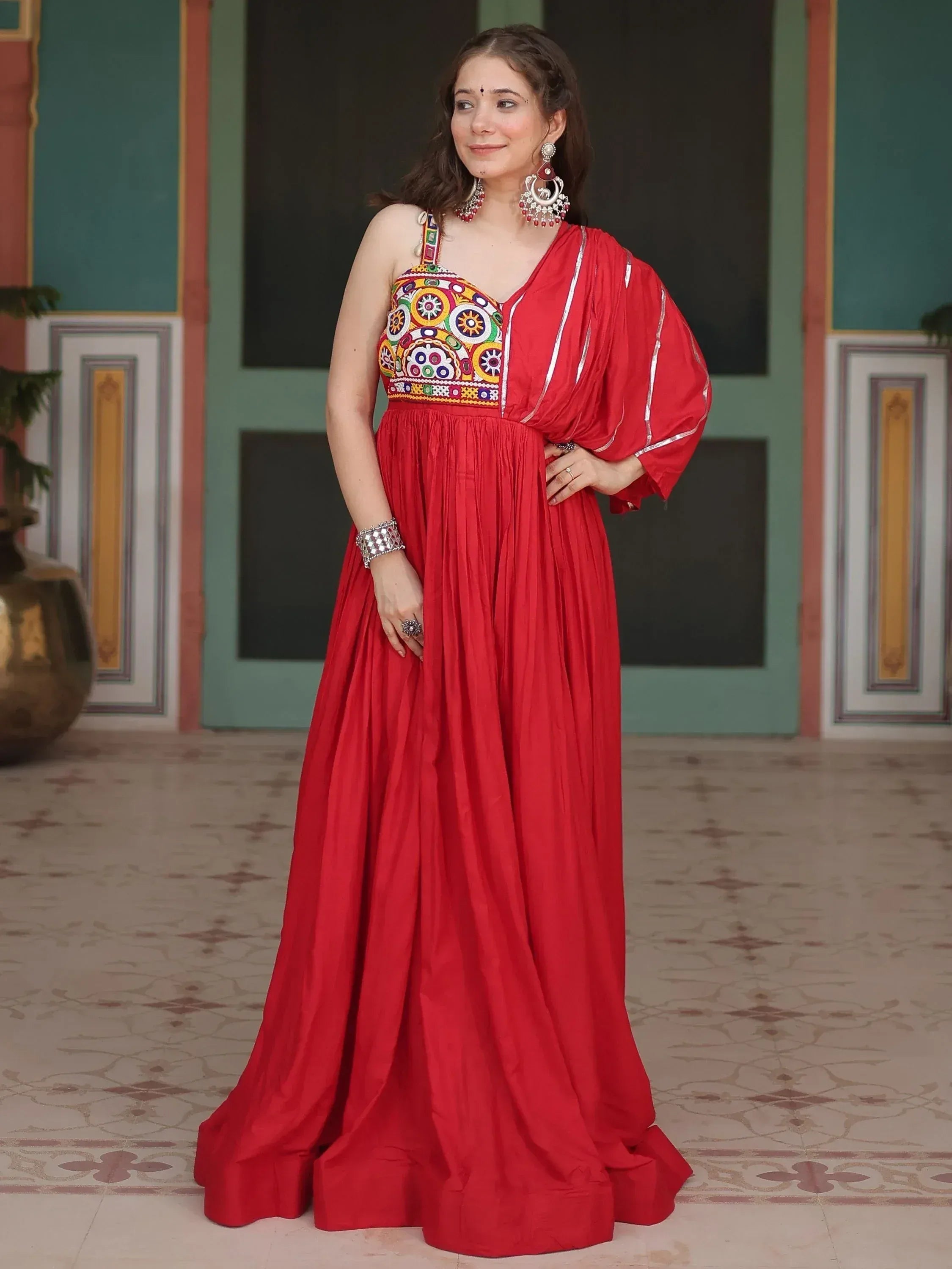 Red ethnic gown with colorful mirror work, perfect for Indian festive occasions and weddings.