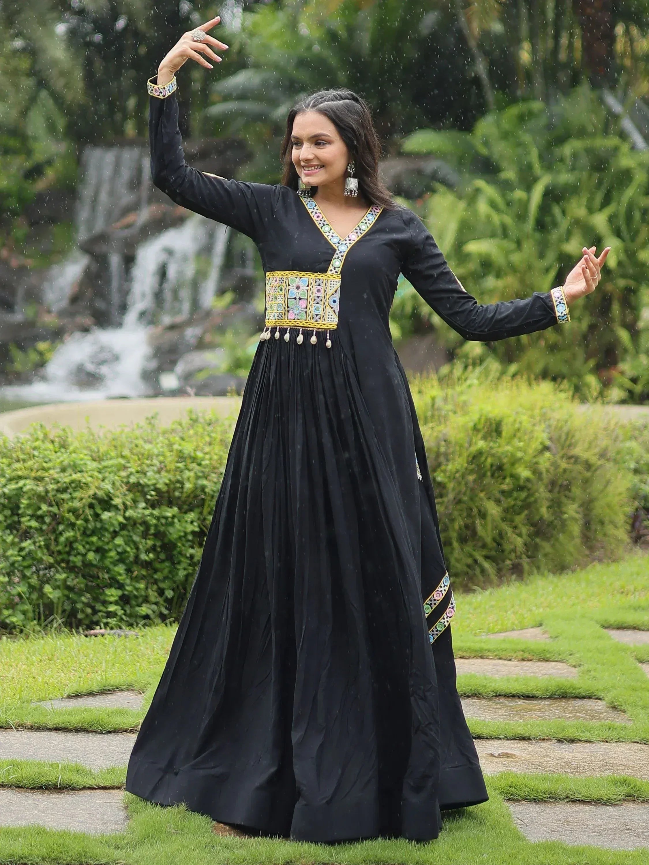 Black ethnic gown with colorful embroidery, worn in garden rain, perfect for Indian festive occasions.