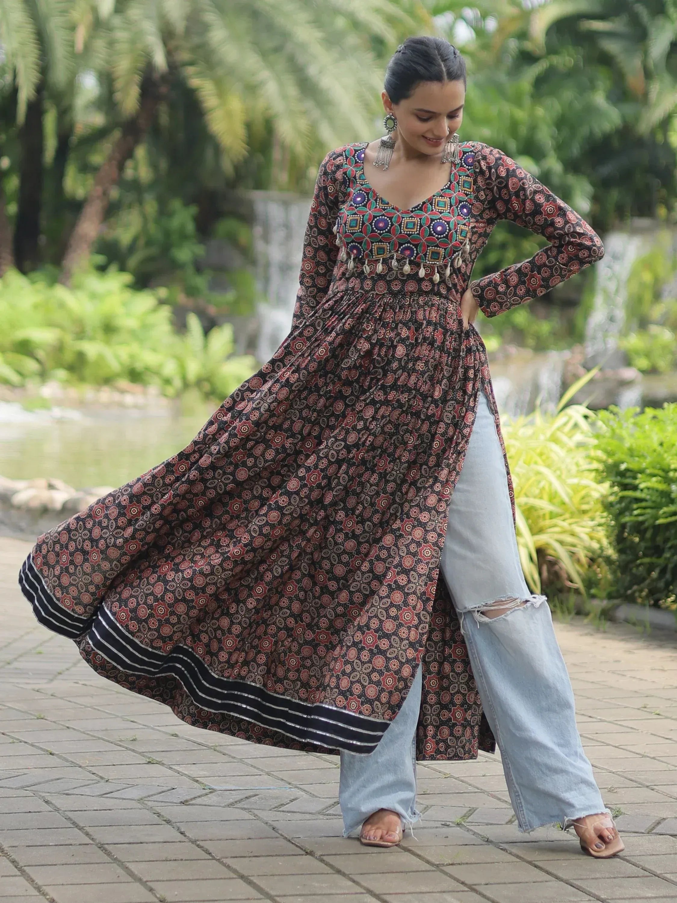 Woman in printed ethnic kurta with mirror work, paired with ripped jeans, outdoors