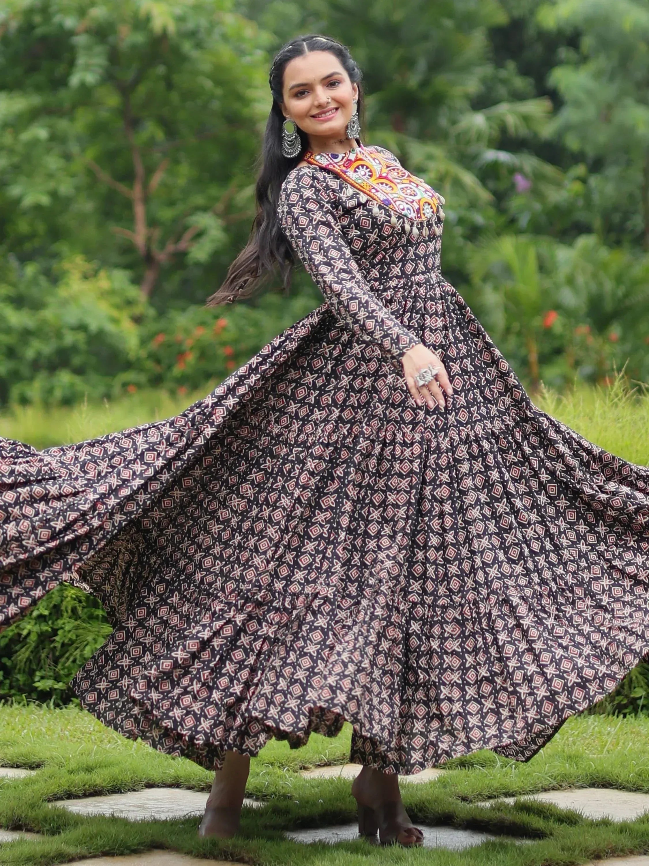 Woman twirling in ethnic printed gown with colorful embroidery, perfect for Indian occasions