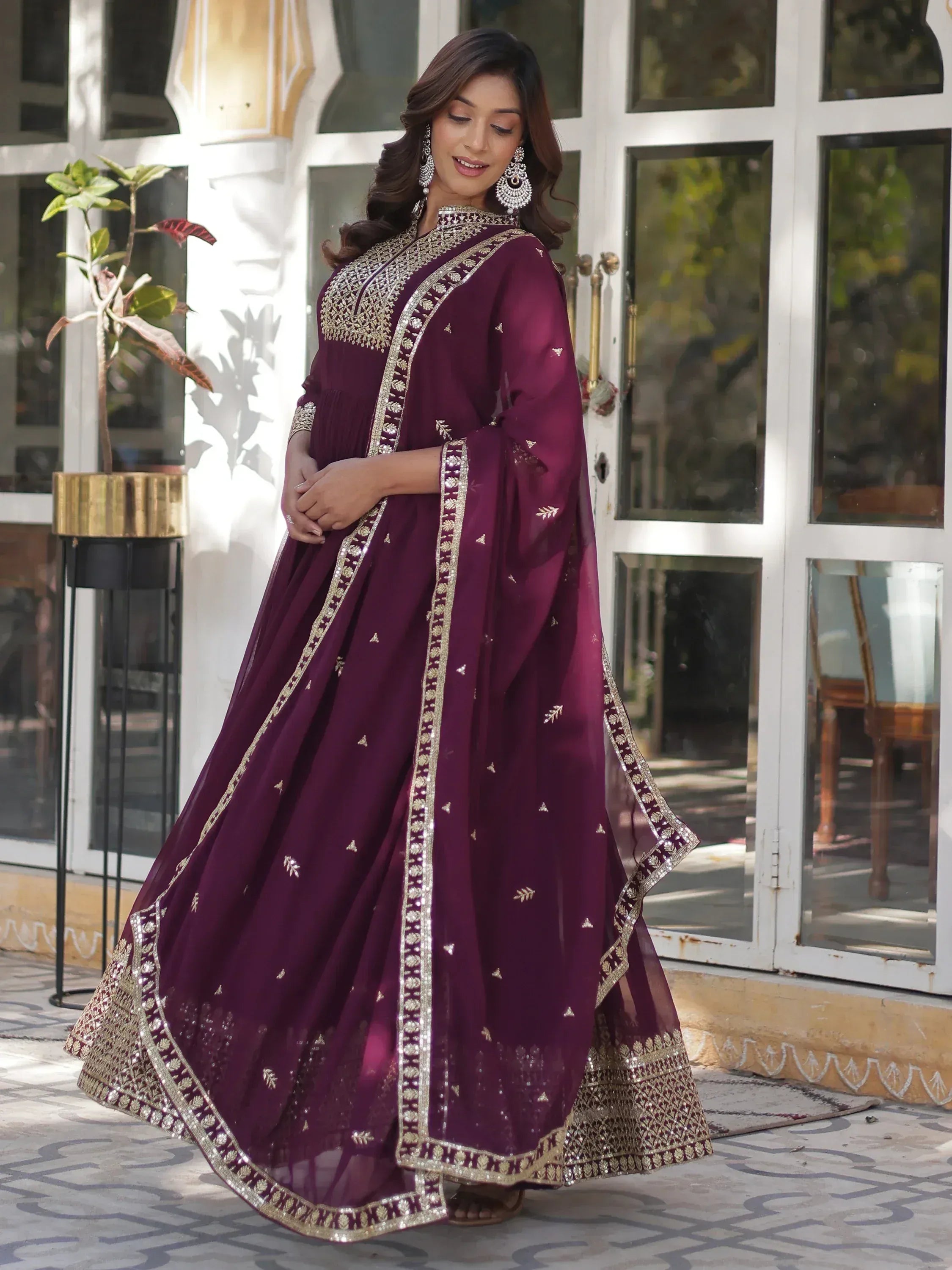 Elegant maroon ethnic gown with gold embroidery, perfect for Indian celebrations and festive occasions.