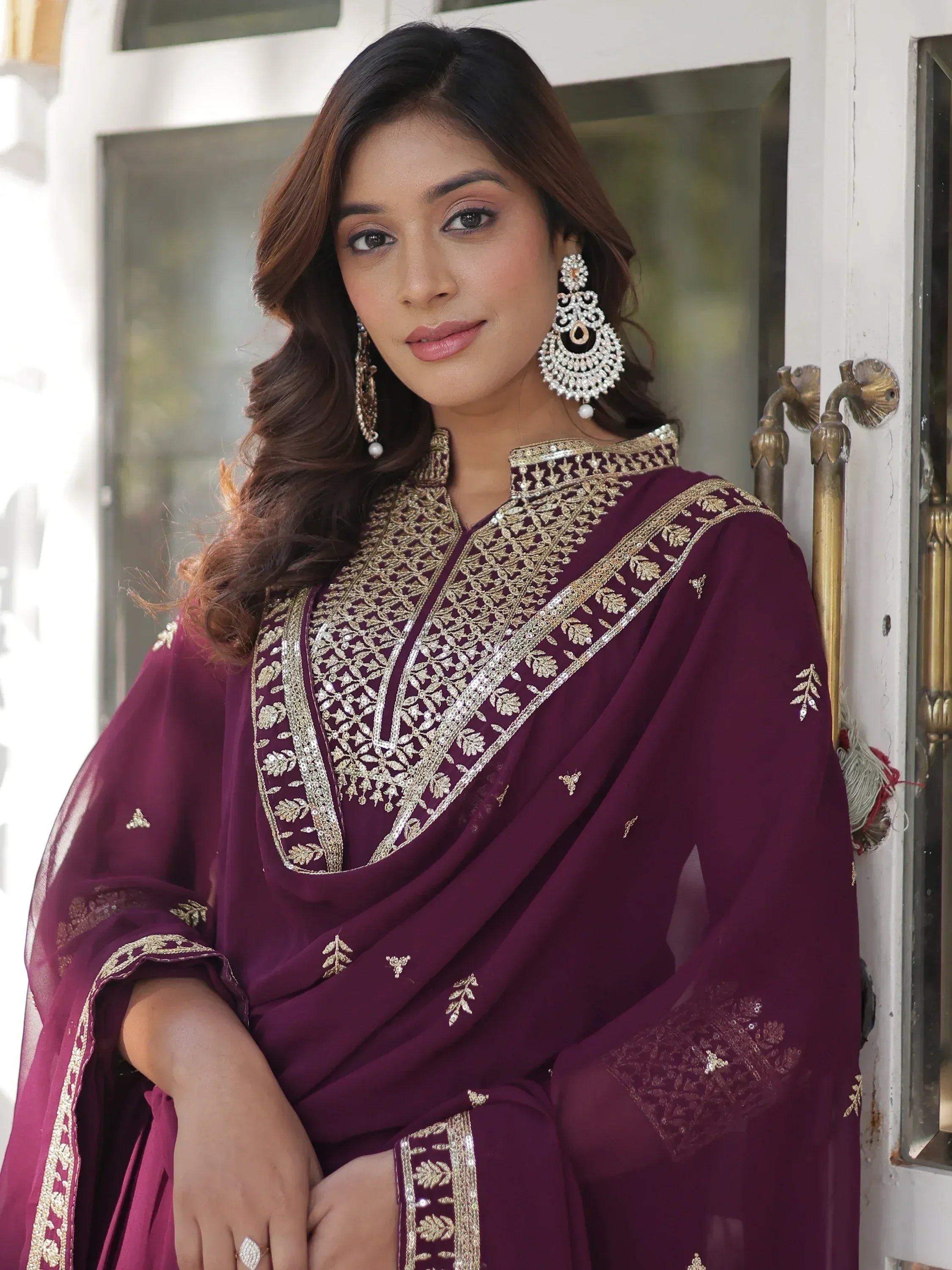 Elegant maroon ethnic gown with gold embroidery, perfect for Indian weddings or festive occasions.