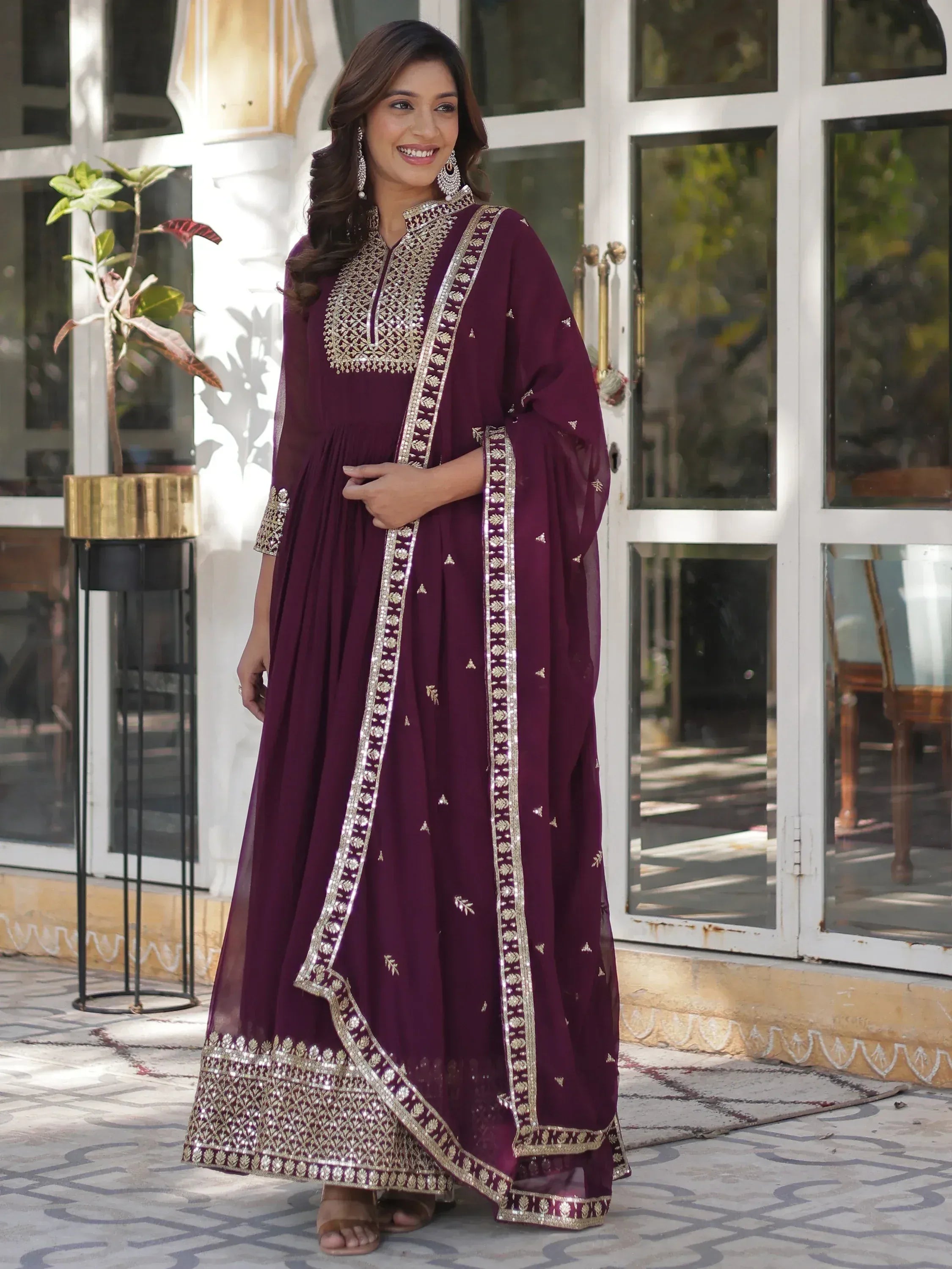 Elegant maroon ethnic gown with gold embroidery, perfect for Indian celebrations and festive occasions.