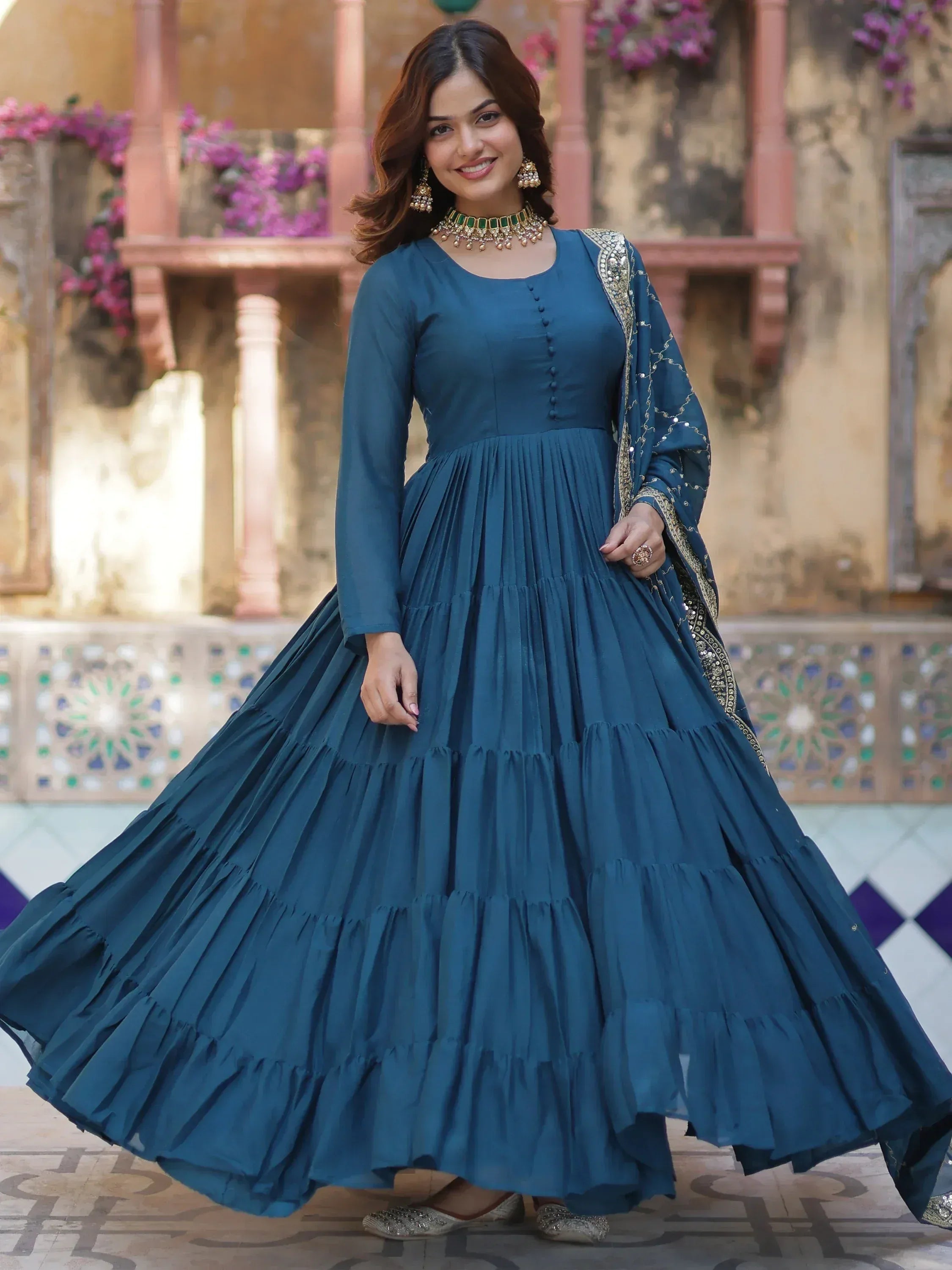 Teal blue ethnic gown with tiered pleated skirt and gold embroidery, perfect for Indian occasions
