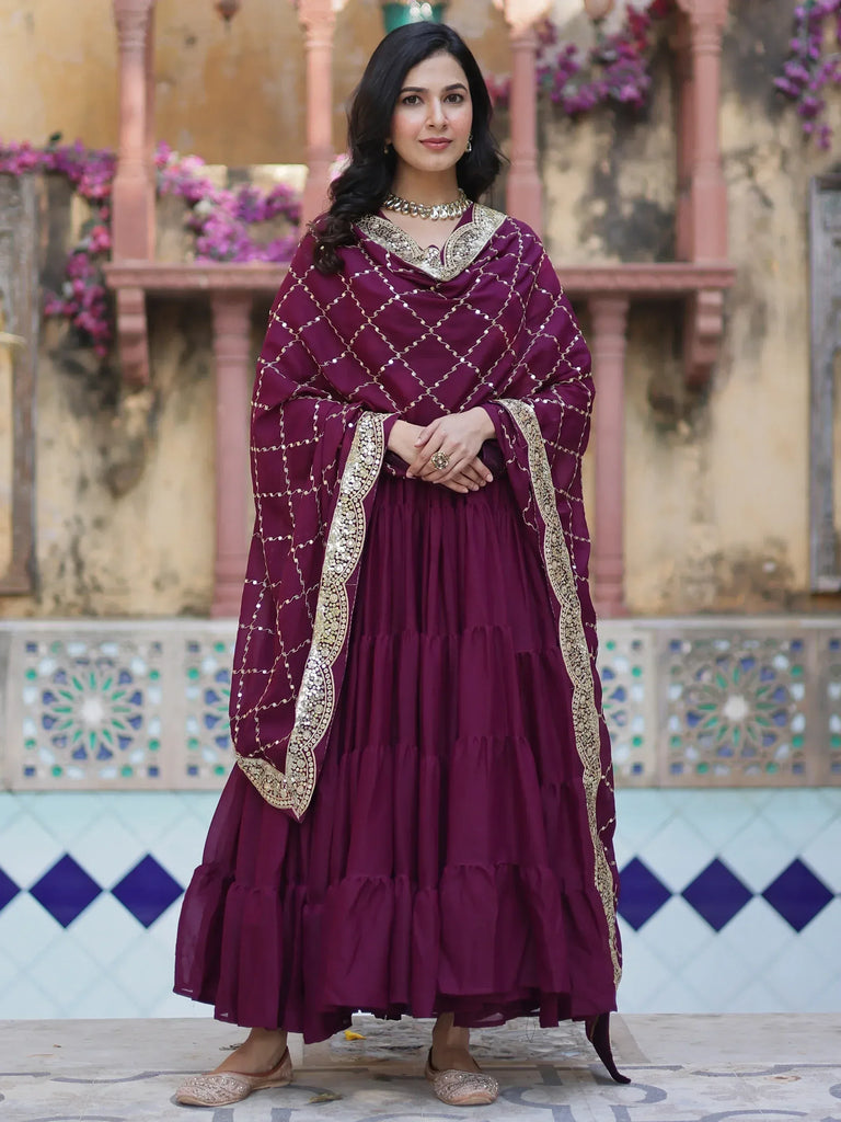 Elegant maroon ethnic gown with gold embroidery and dupatta, perfect for Indian occasions
