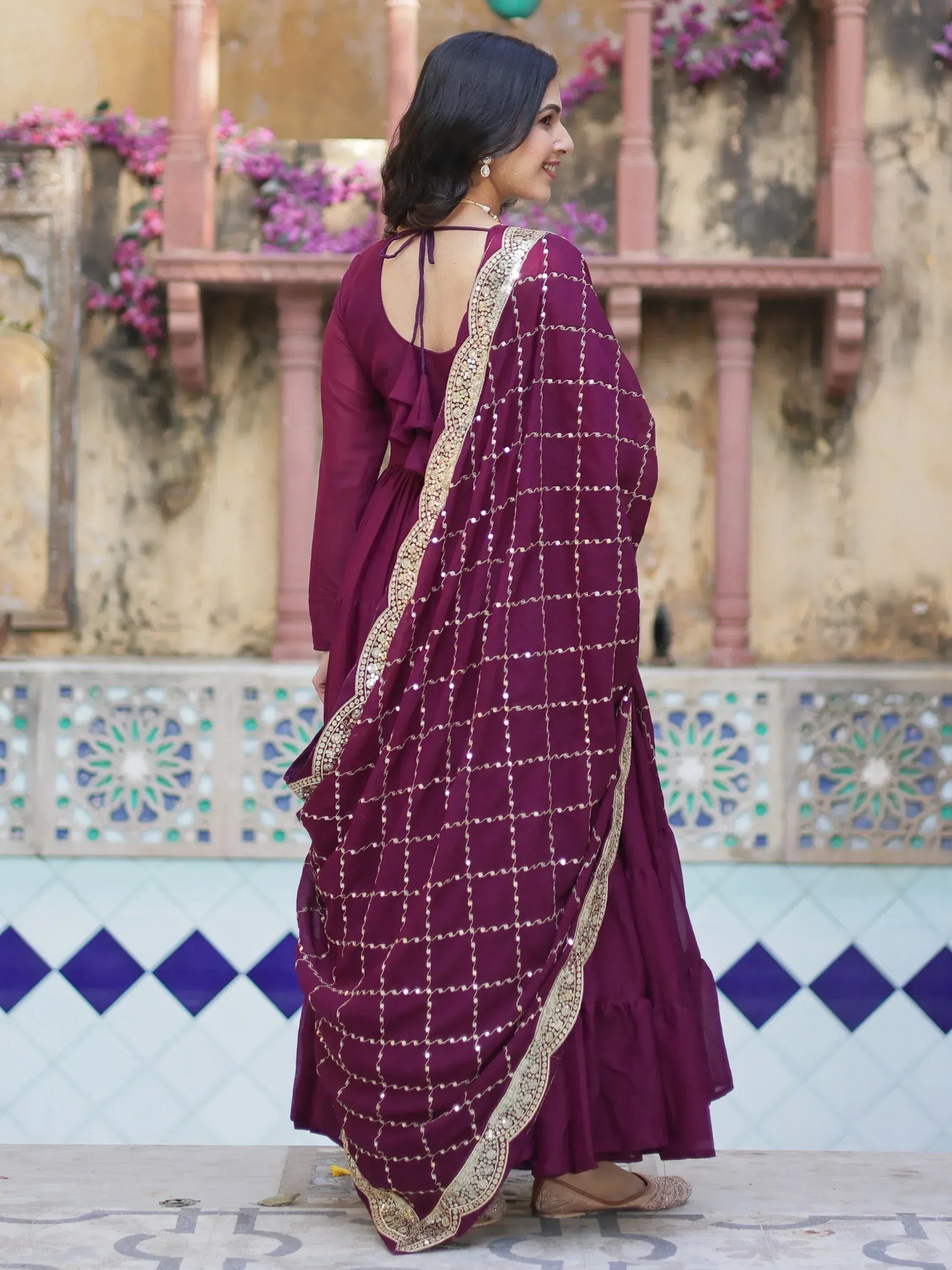 Elegant maroon ethnic gown with gold embroidery and mirror work, perfect for Indian occasions