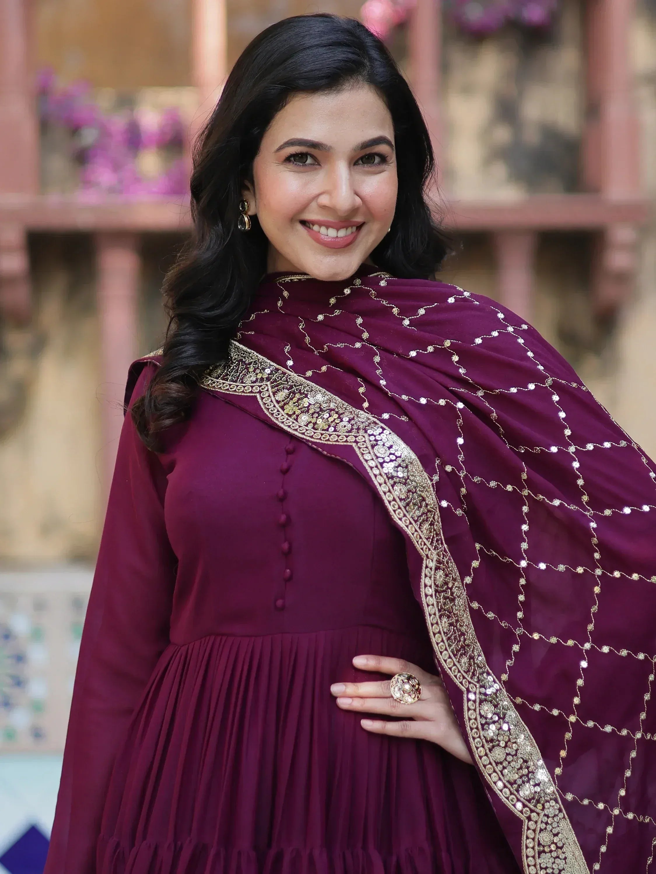 Woman in maroon ethnic gown with gold embroidery and sequin dupatta, perfect for Indian occasions