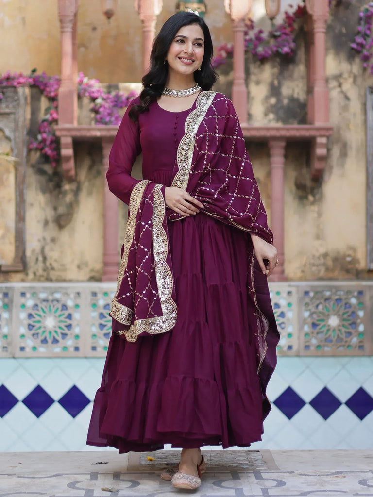 Elegant maroon ethnic gown with gold embroidery, perfect for Indian festive occasions and weddings.