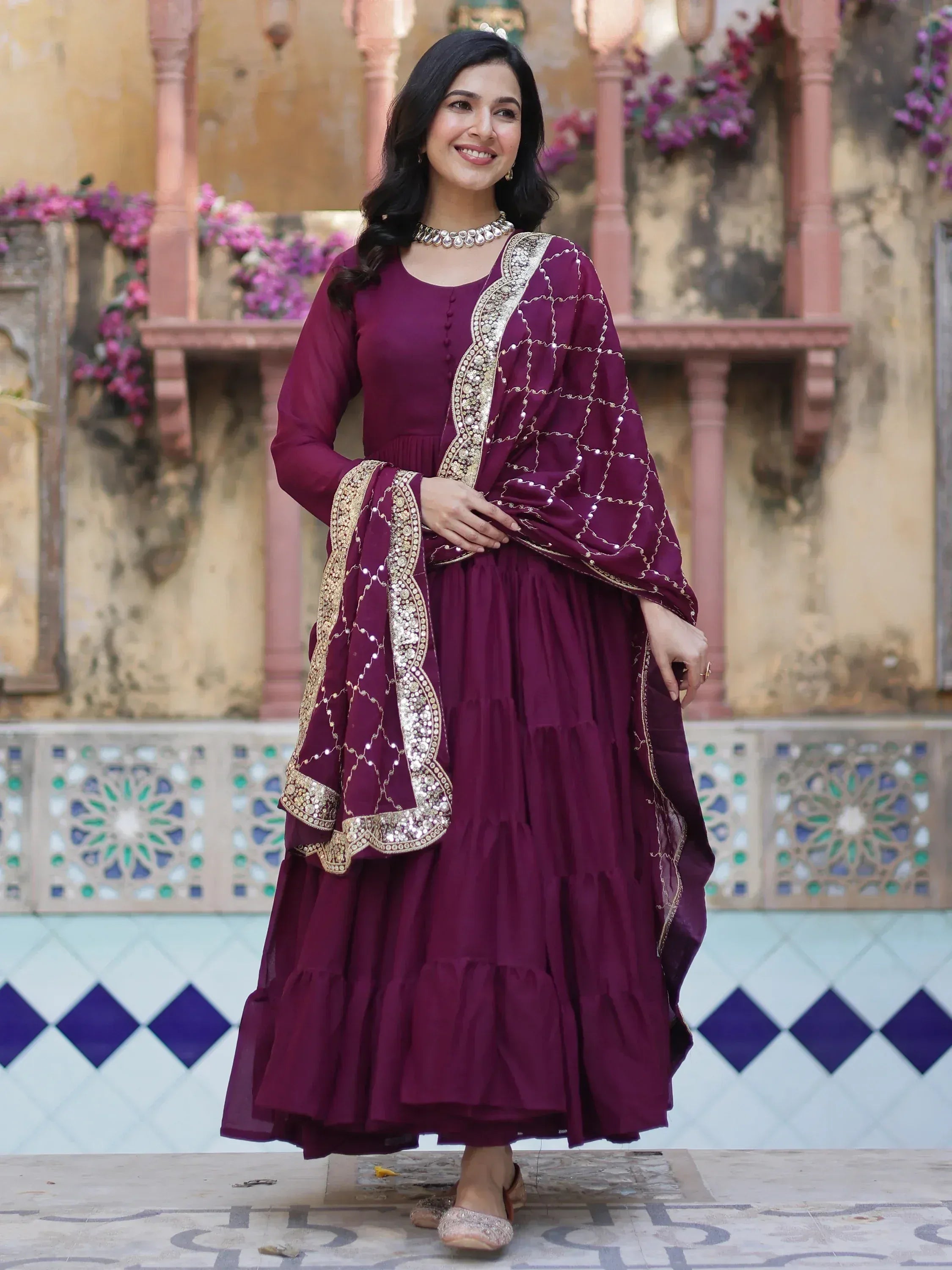 Elegant maroon ethnic gown with gold embroidery, perfect for Indian festive occasions and weddings.