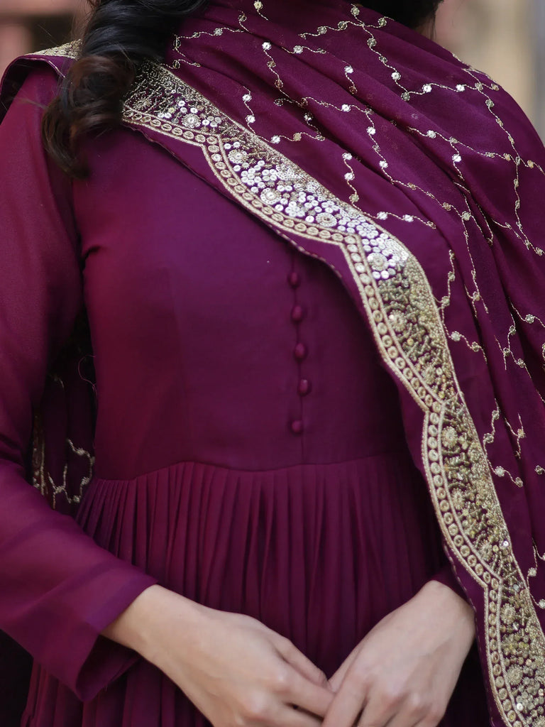 Elegant maroon ethnic gown with gold embroidery and sequin dupatta, perfect for Indian occasions.