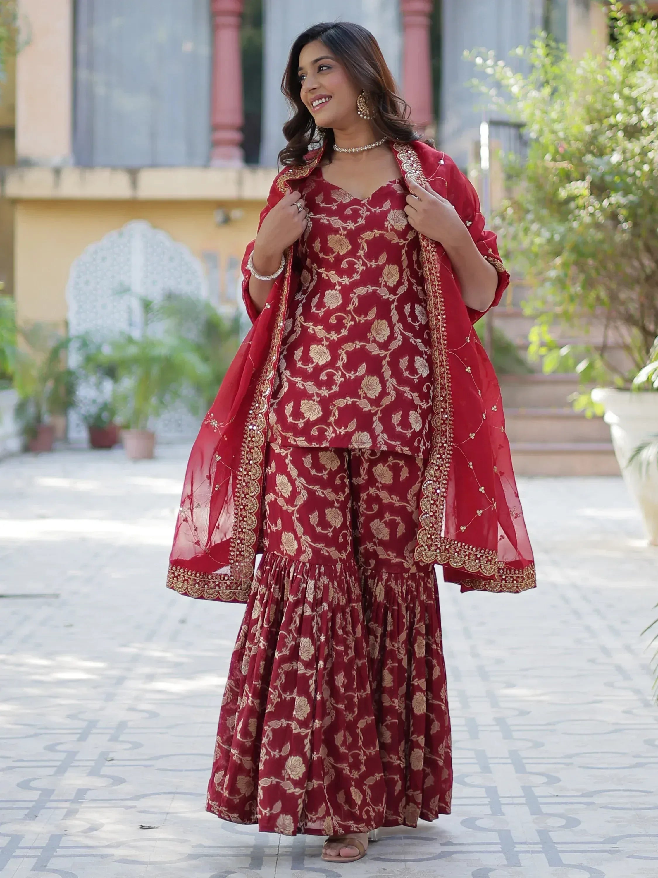 Red floral ethnic salwar kameez with gold embroidery and dupatta, perfect for festive occasions.