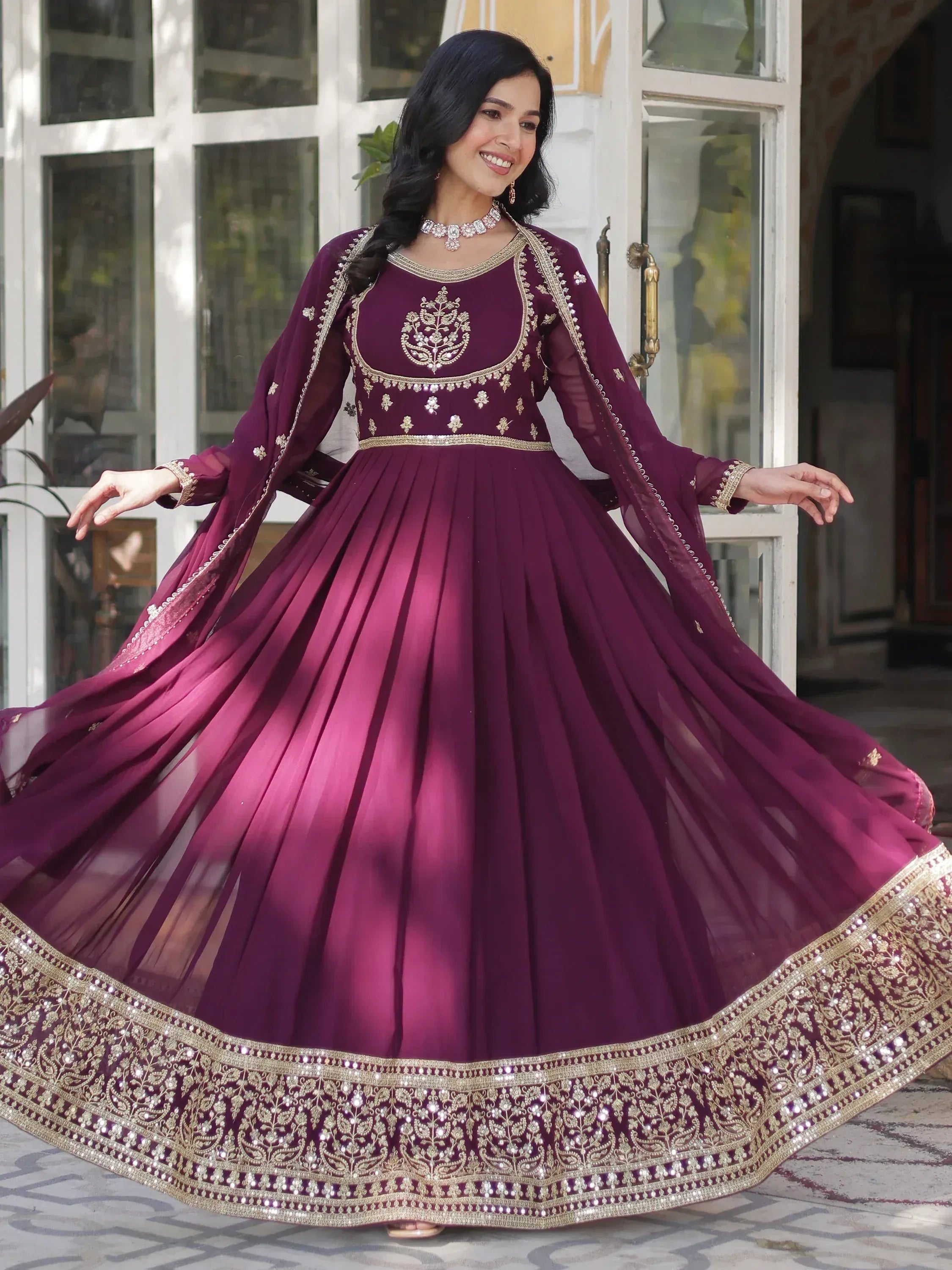 Elegant maroon ethnic gown with gold embroidery, perfect for Indian weddings and festive occasions.