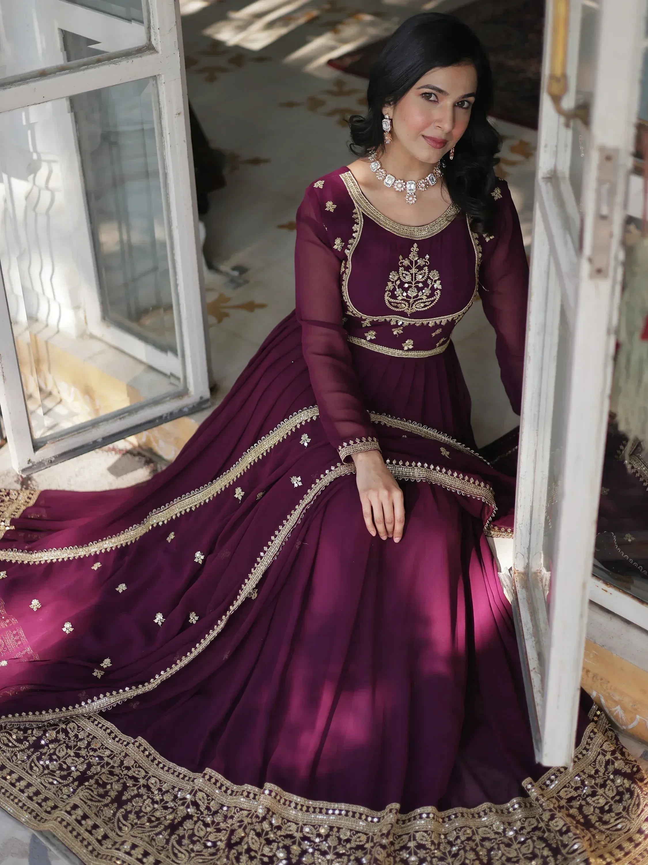 Elegant maroon ethnic gown with gold embroidery, perfect for Indian weddings and festive occasions.