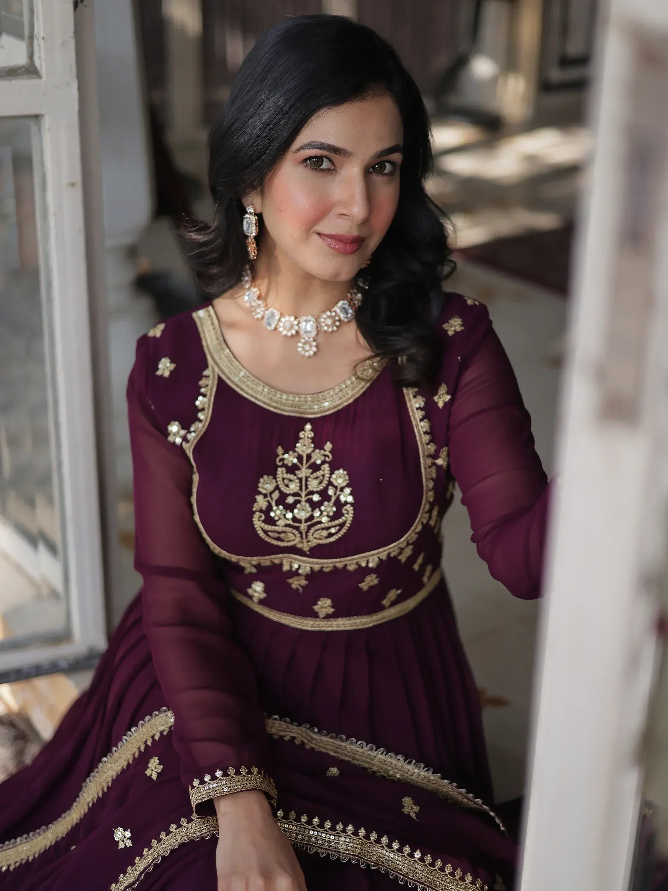 Elegant maroon ethnic gown with gold embroidery, perfect for Indian occasions and festive wear.
