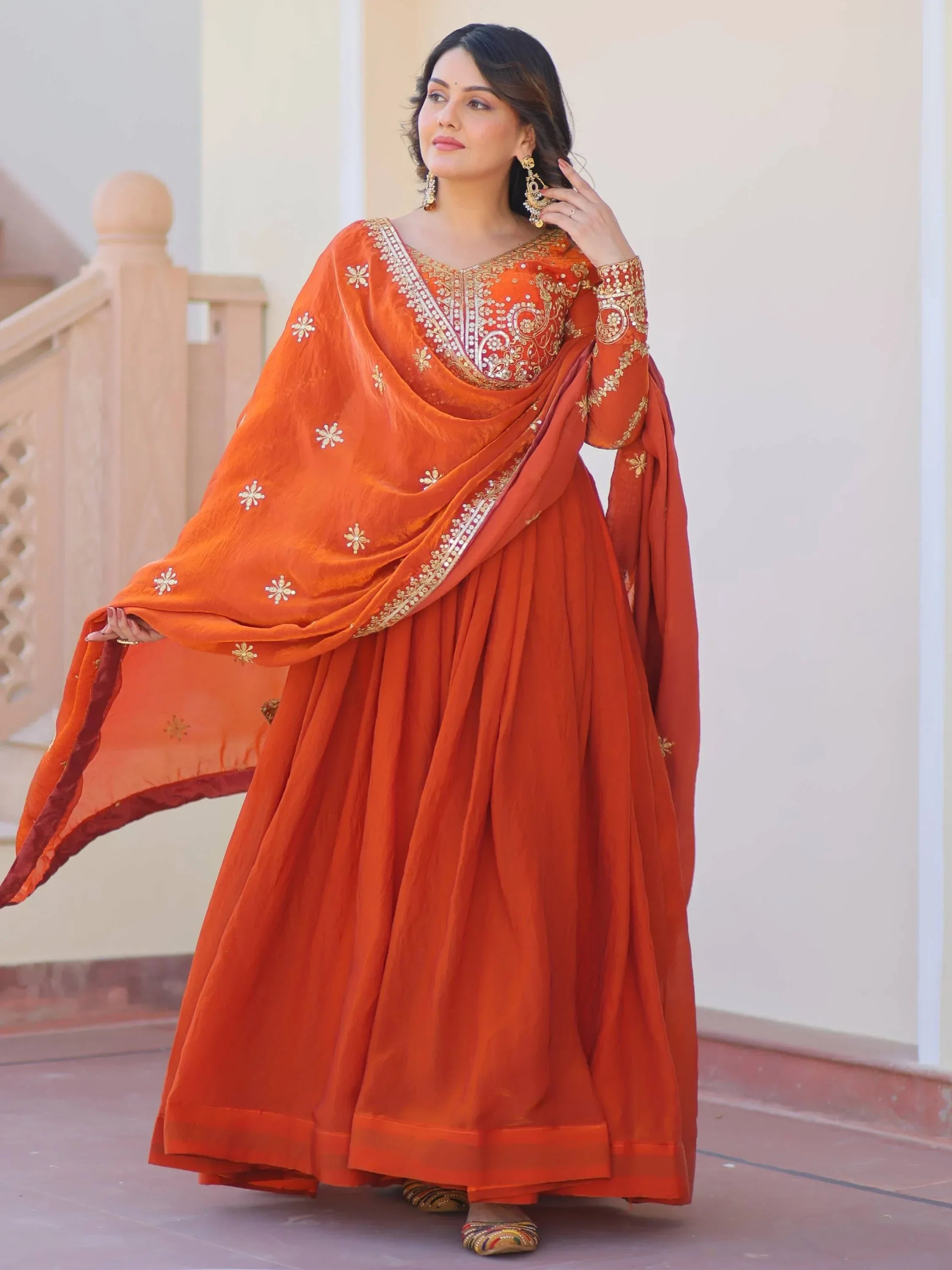 Woman wearing orange embroidered Anarkali suit with dupatta, traditional Indian ethnic wear