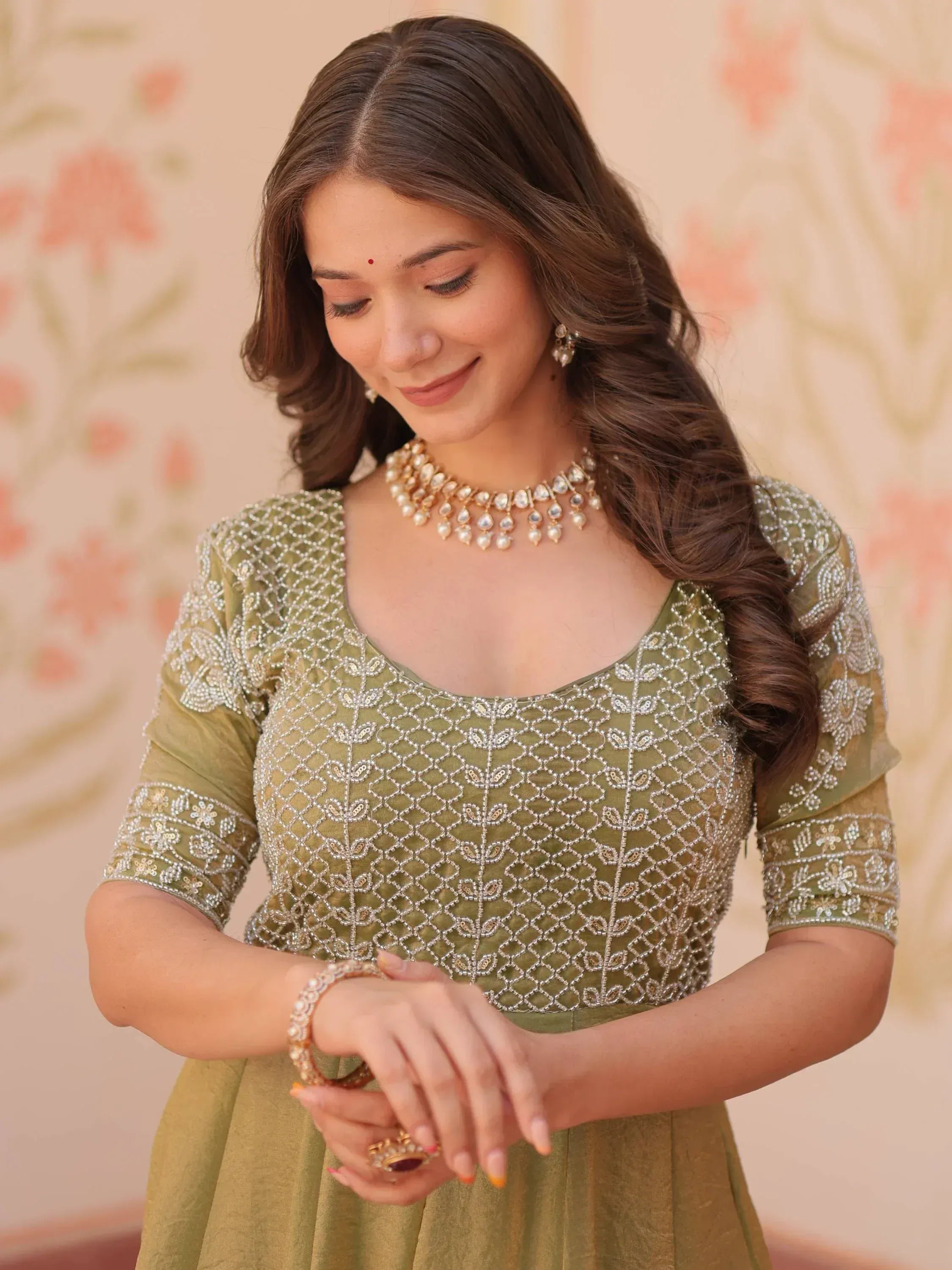 Olive green embroidered ethnic gown with pearl jewelry for Indian occasions