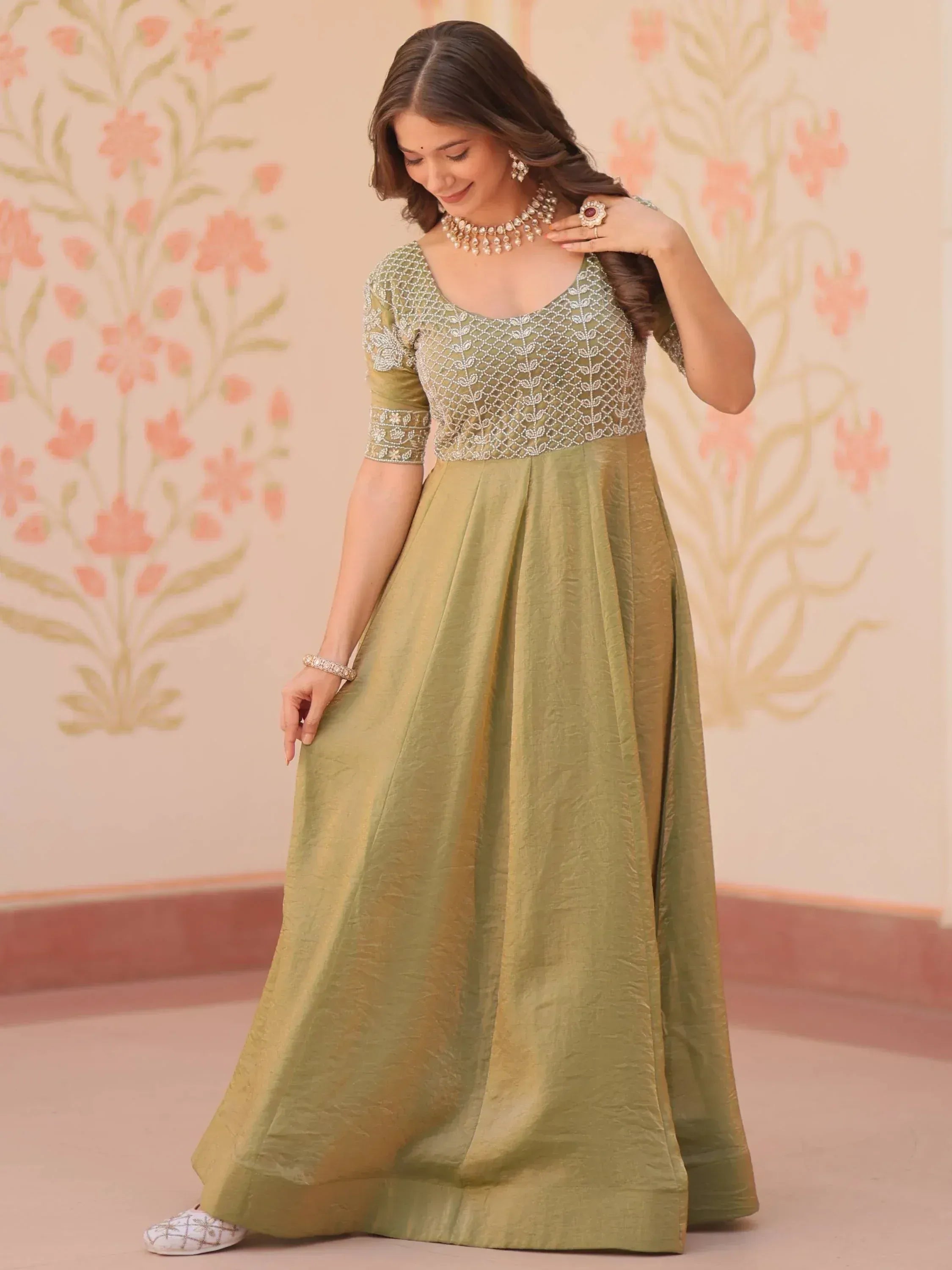 Elegant olive green ethnic gown with intricate embroidery and pearl jewelry
