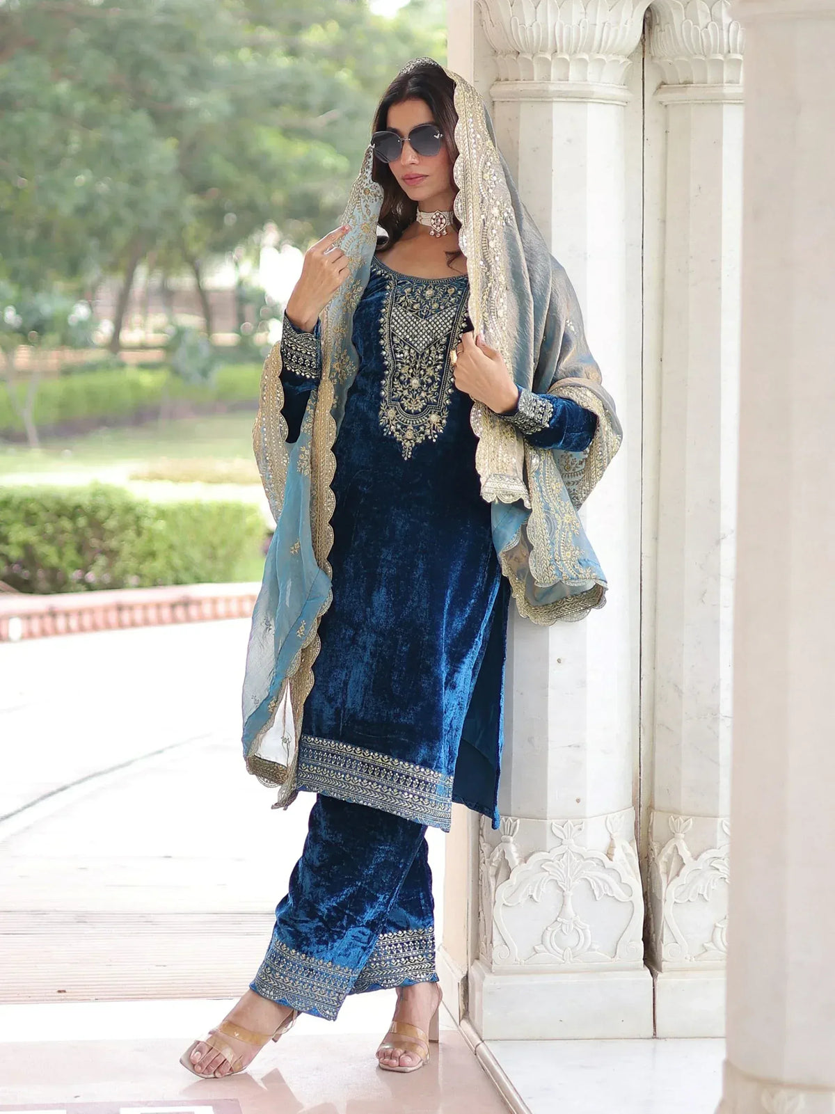 Elegant blue velvet salwar kameez with gold embroidery, paired with matching dupatta for festive occasions