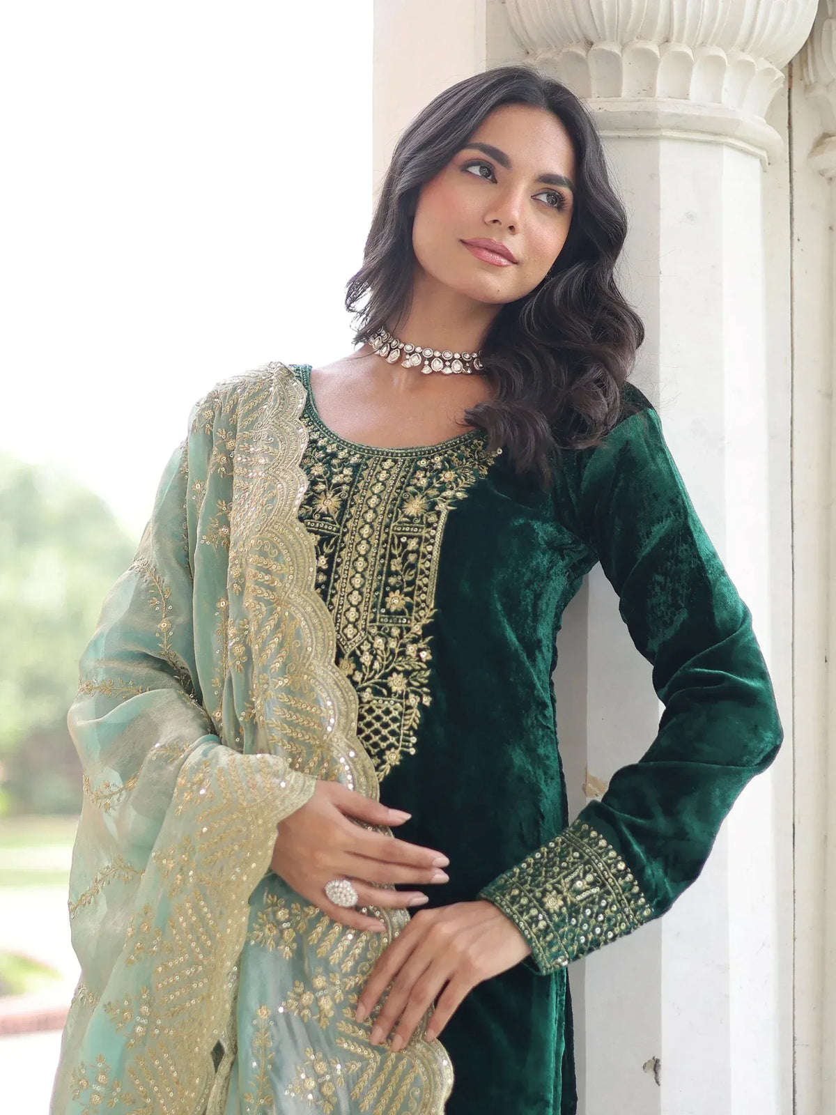 Emerald green velvet salwar kameez with gold embroidery and sheer dupatta, perfect for ethnic occasions.