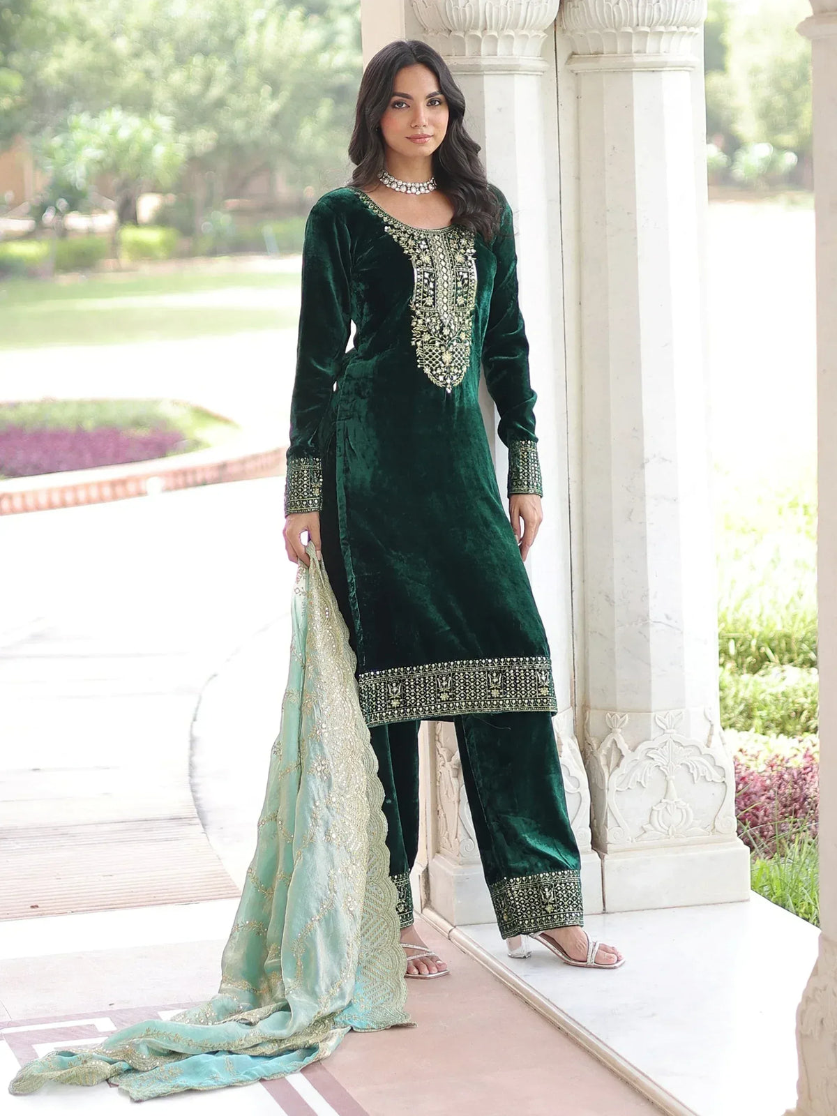 Emerald green velvet salwar kameez with gold embroidery, paired with light green dupatta, perfect for festive occasions.