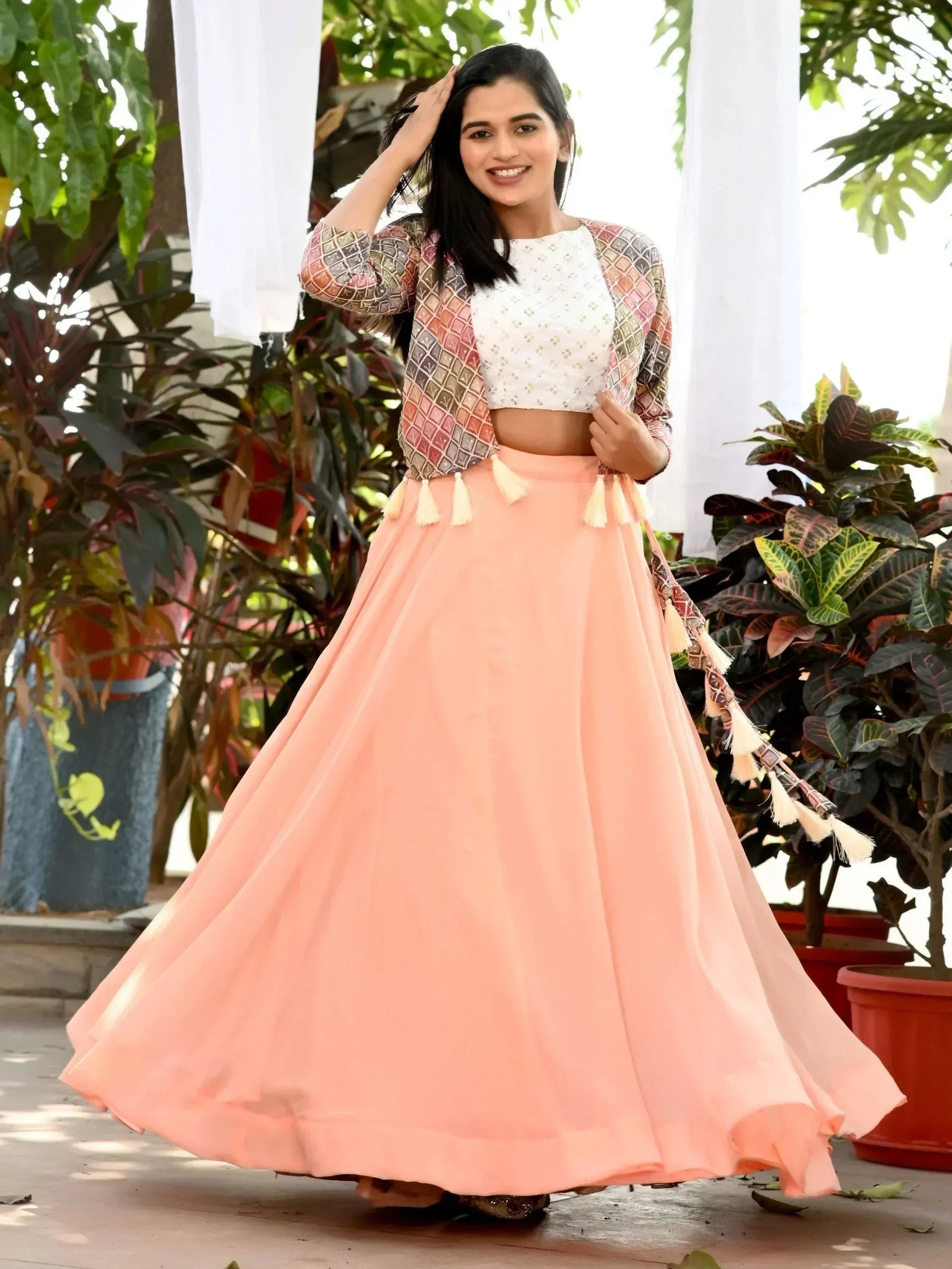 Peach lehenga with tassels, embroidered white crop top, and printed jacket for Indian ethnic wear