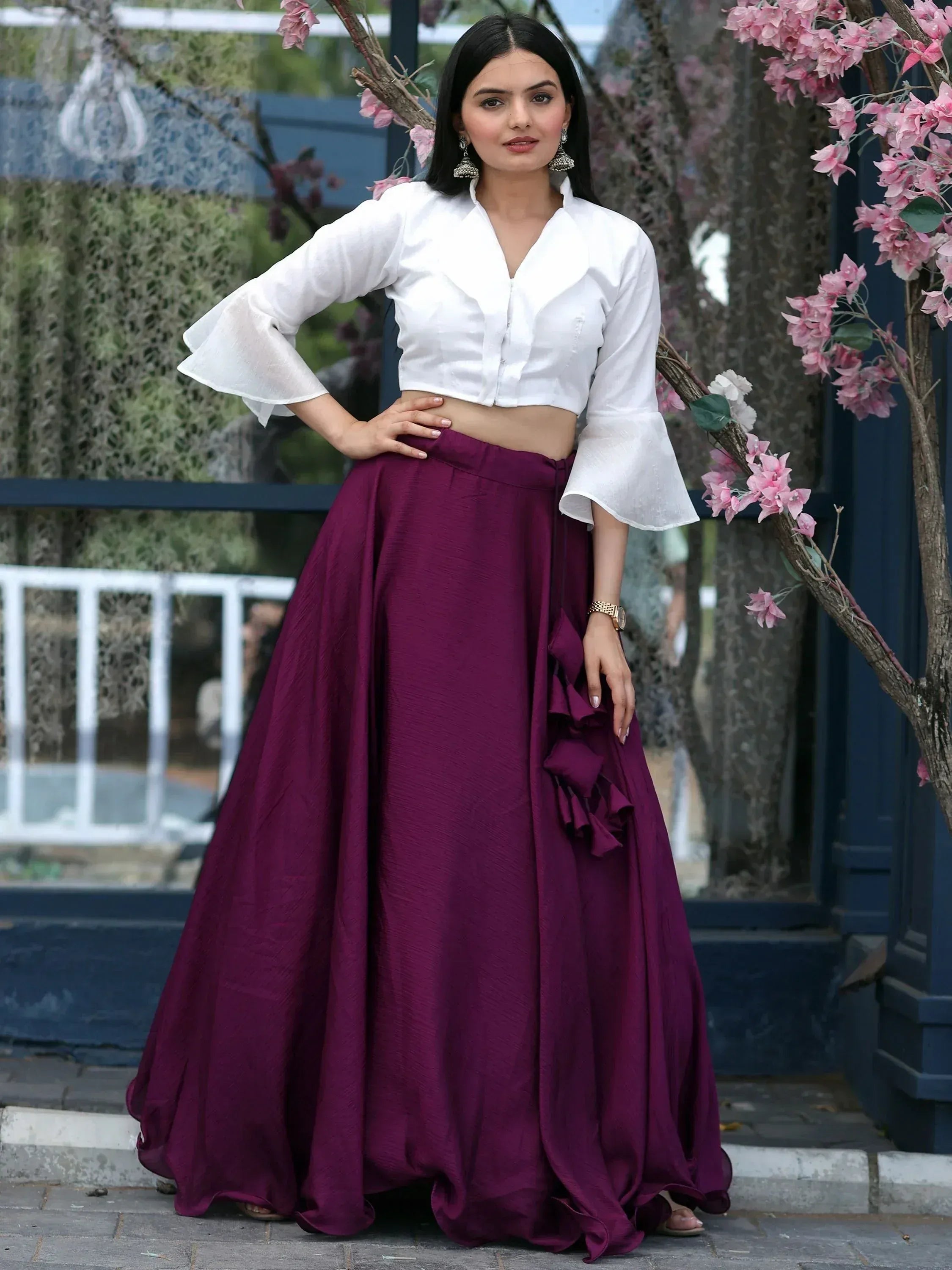 Woman in white crop top with bell sleeves and purple ruffled lehenga skirt, Indian ethnic wear