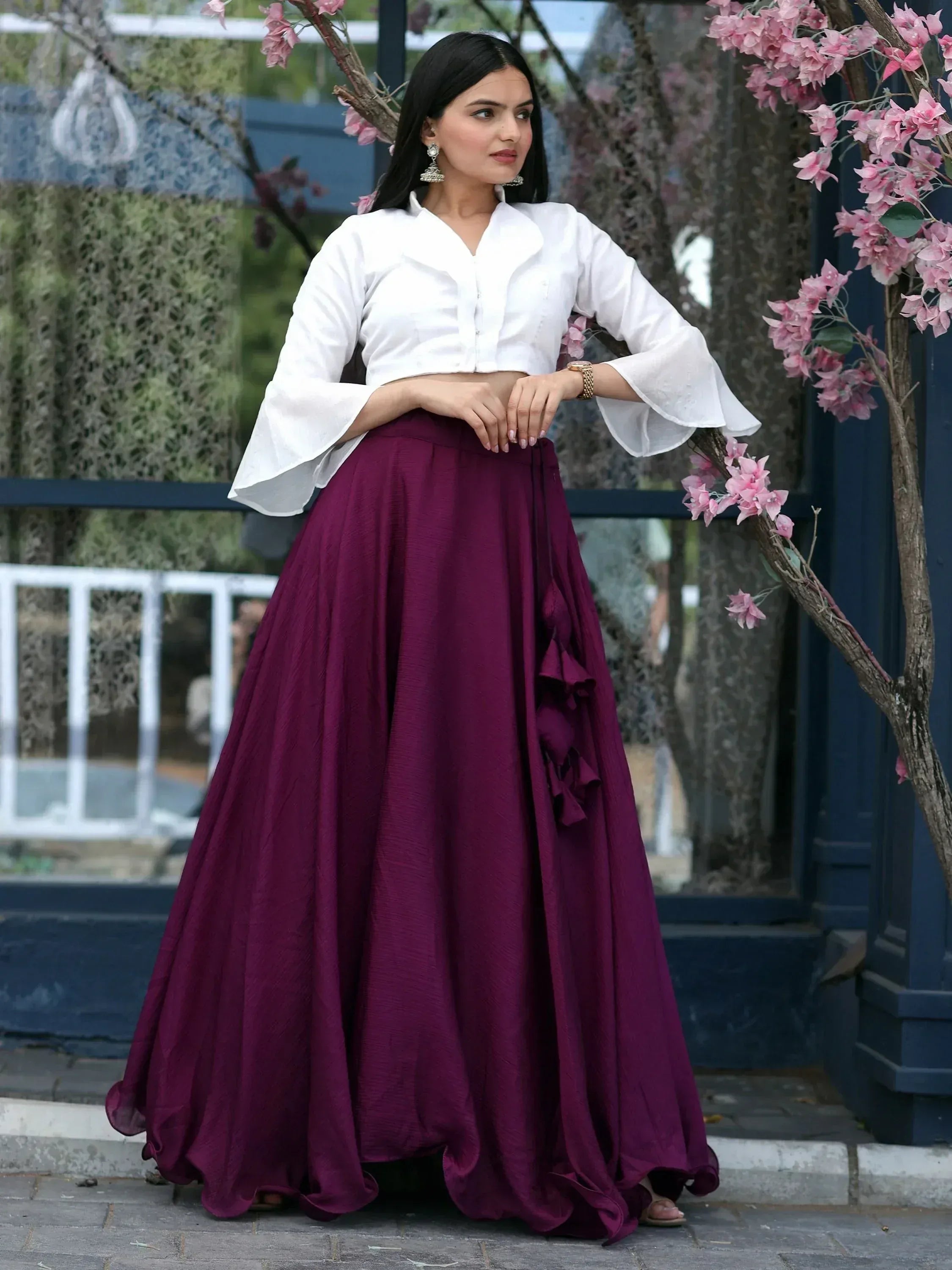 Woman in white crop top with bell sleeves and maroon ruffle skirt, ethnic wear outfit