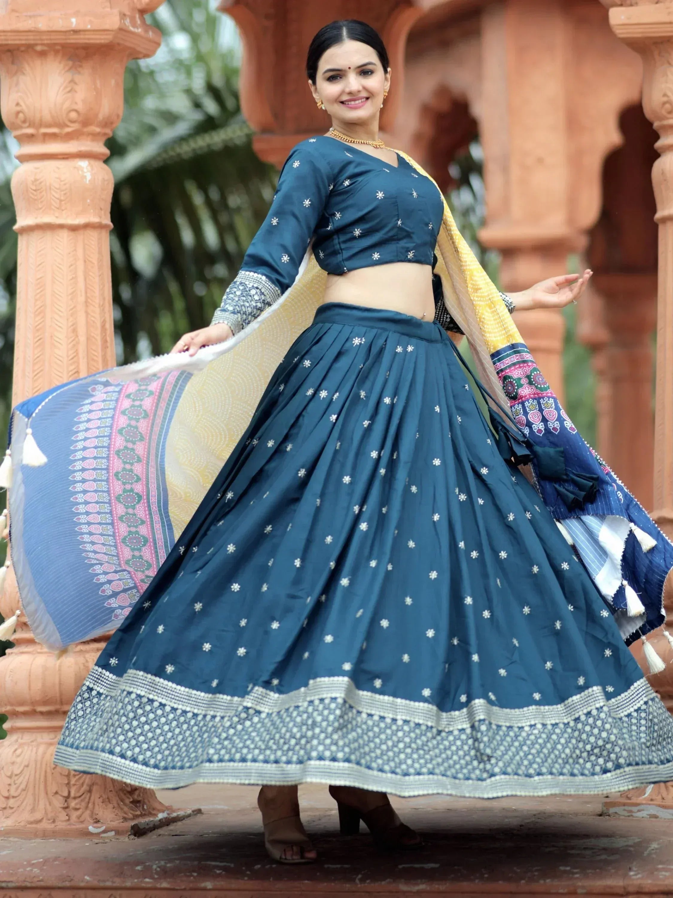 Woman in blue embroidered lehenga choli with yellow dupatta, traditional Indian ethnic wear