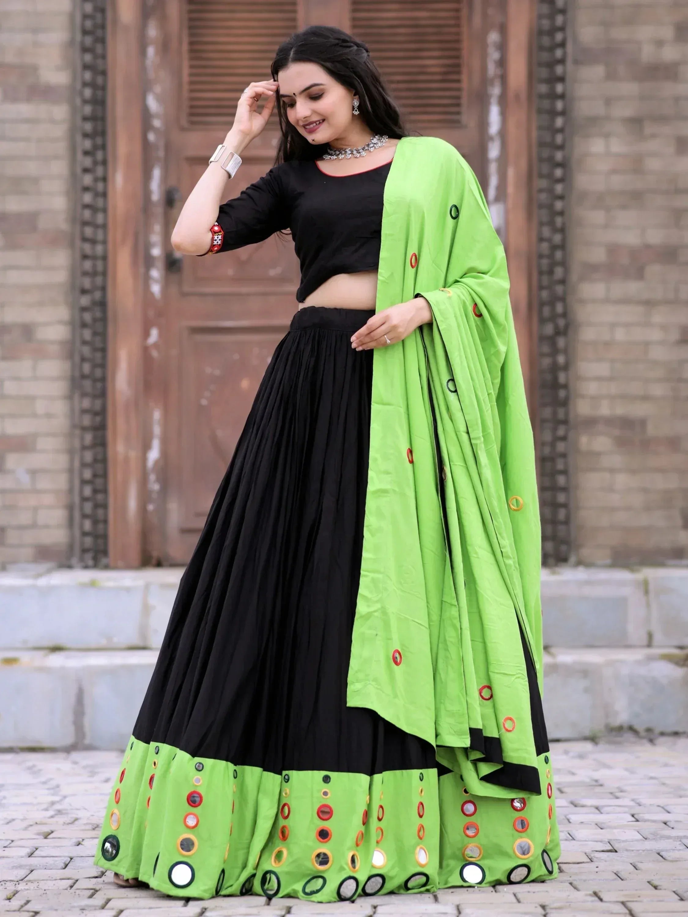 Black and neon green ethnic lehenga choli with mirror work, perfect for Indian festive occasions.