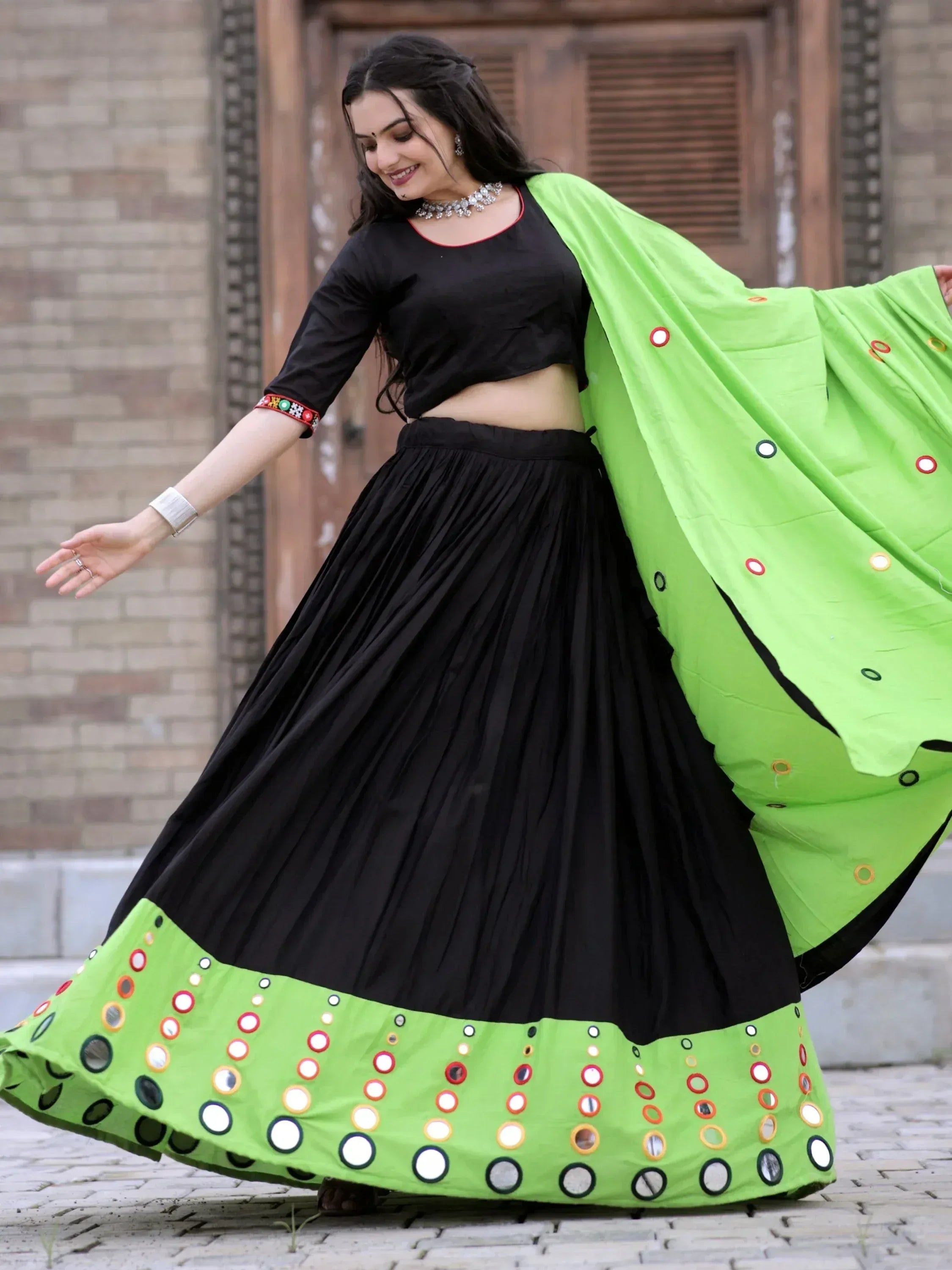 Black and neon green mirror-work lehenga choli with pleated skirt and dupatta, perfect for Indian ethnic wear