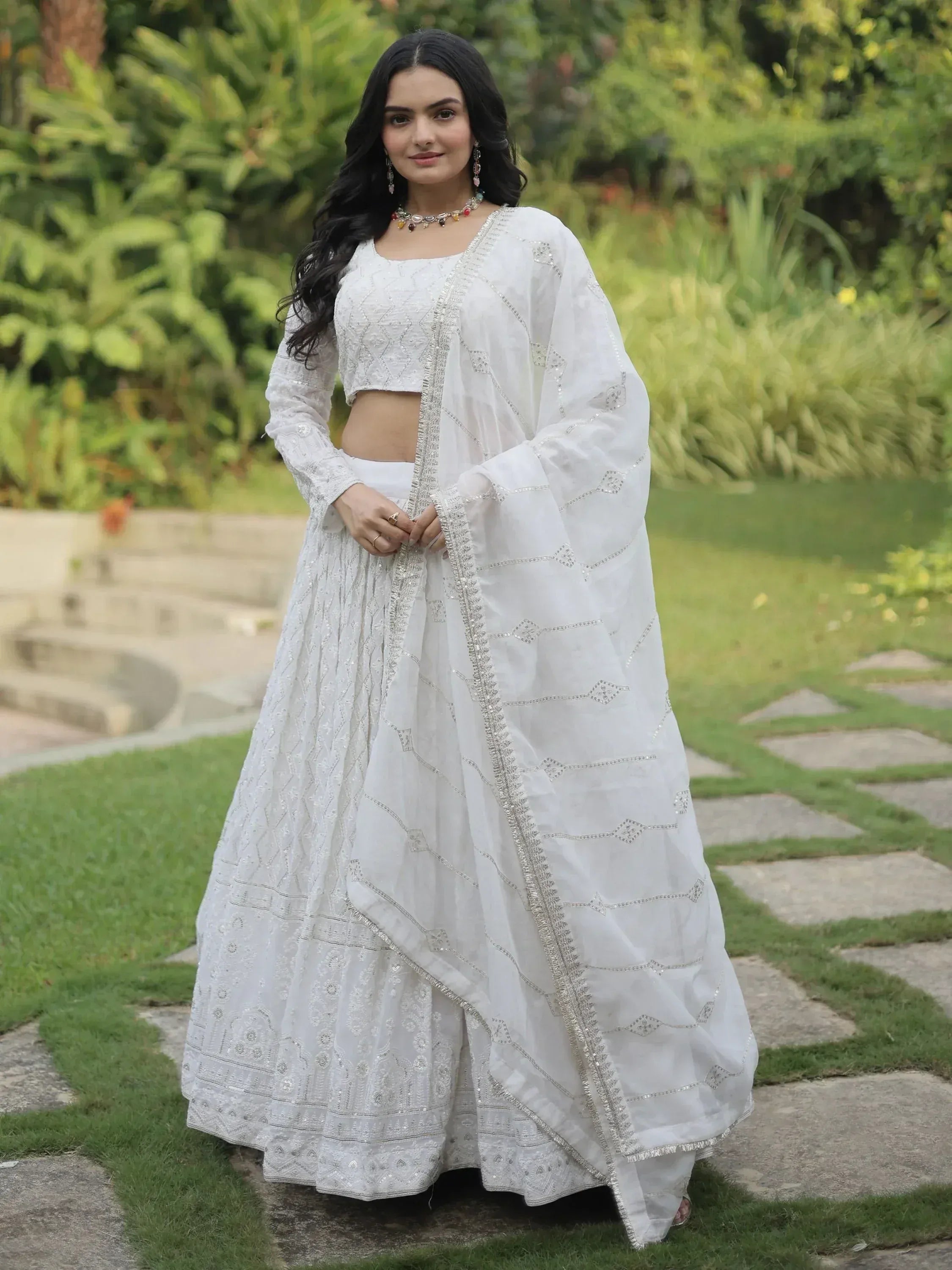 White embroidered lehenga choli with dupatta, Indian ethnic wear for women, garden setting