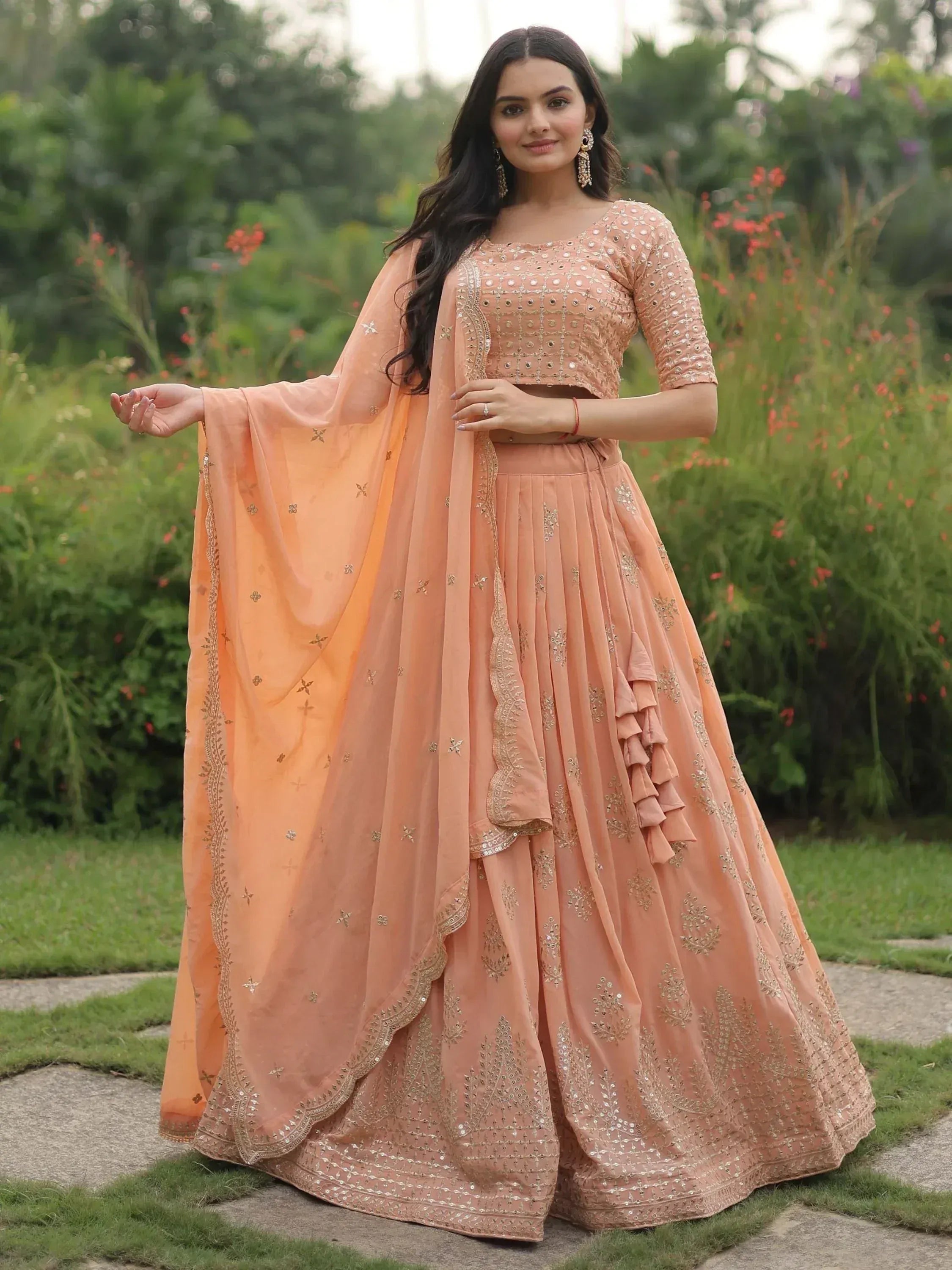 Peach designer lehenga choli with gold embroidery and ruffle detailing, perfect for Indian ethnic wear