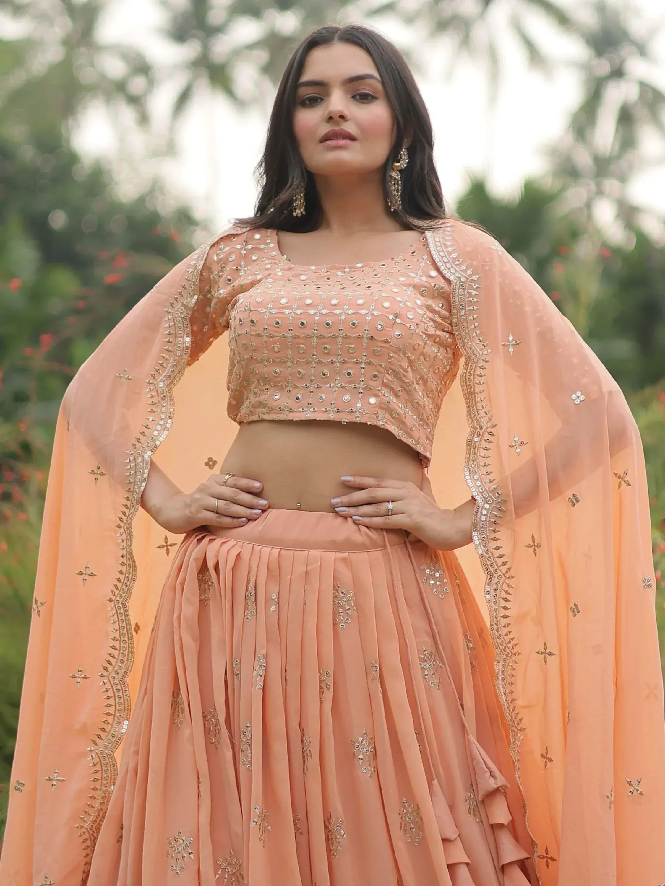Peach designer lehenga choli with mirror work and cape sleeves, perfect for Indian ethnic occasions