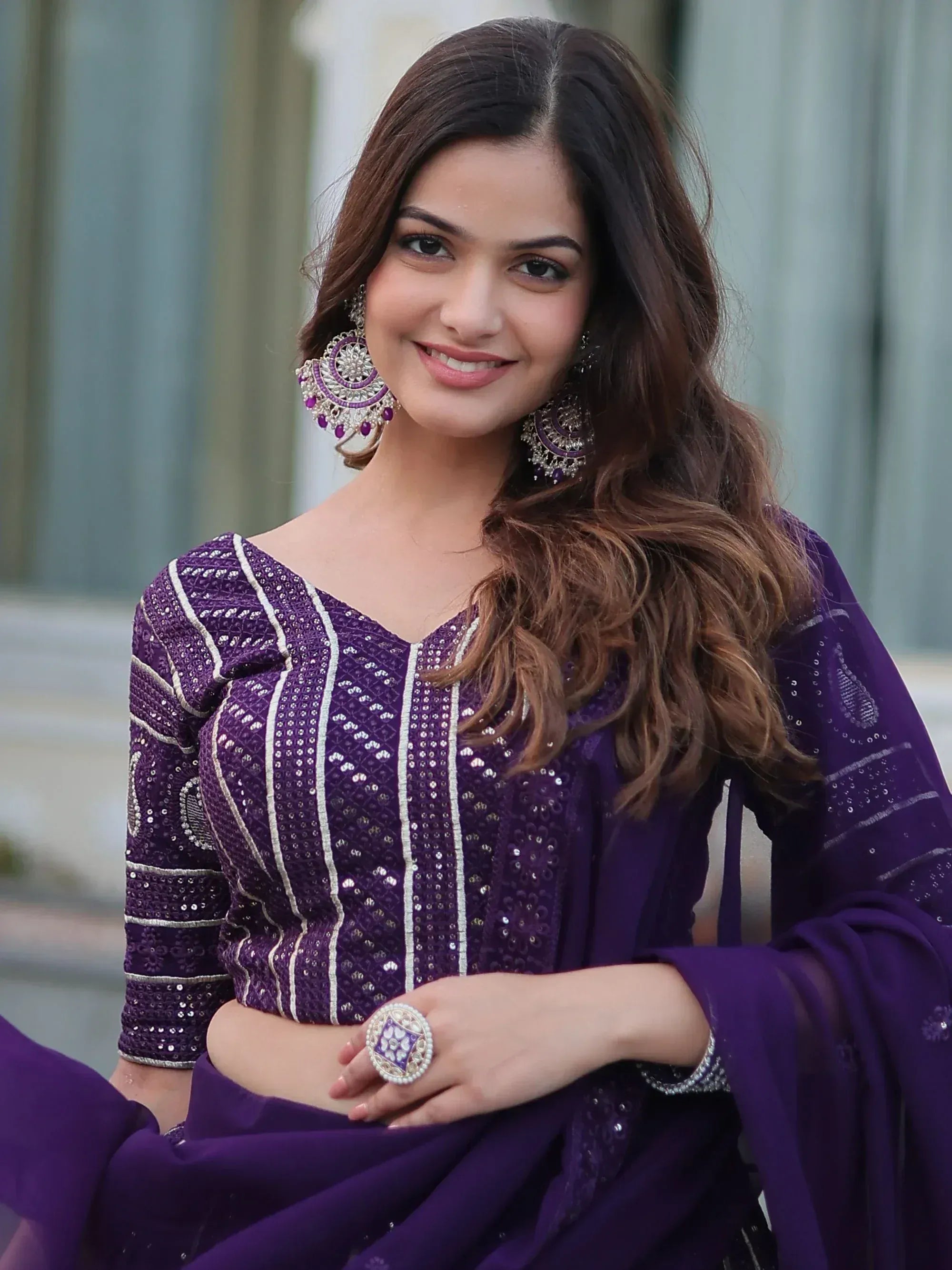 Purple embroidered salwar kameez with mirror work, paired with statement earrings and ring for festive occasions