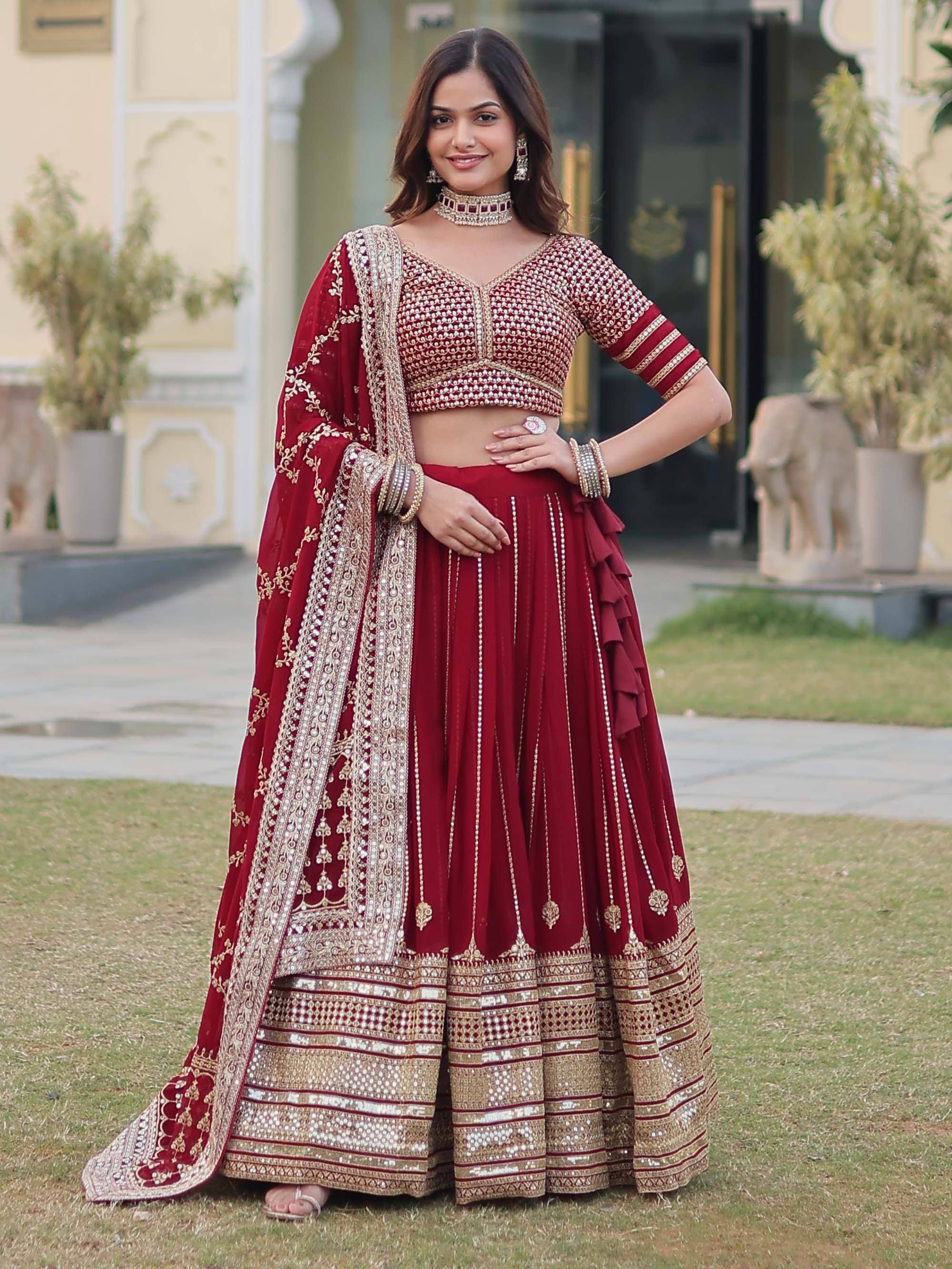 Maroon designer lehenga choli with heavy gold embroidery and mirror work, perfect for Indian weddings and festive occasions.