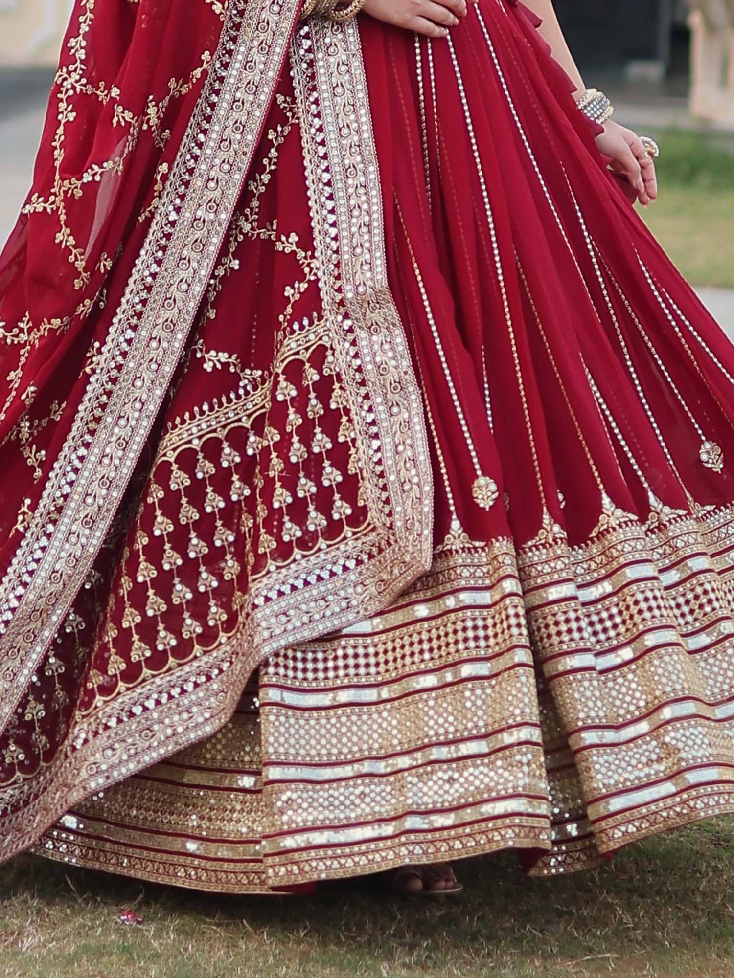 Red designer lehenga choli with gold embroidery and mirror work, perfect for Indian weddings and festive occasions