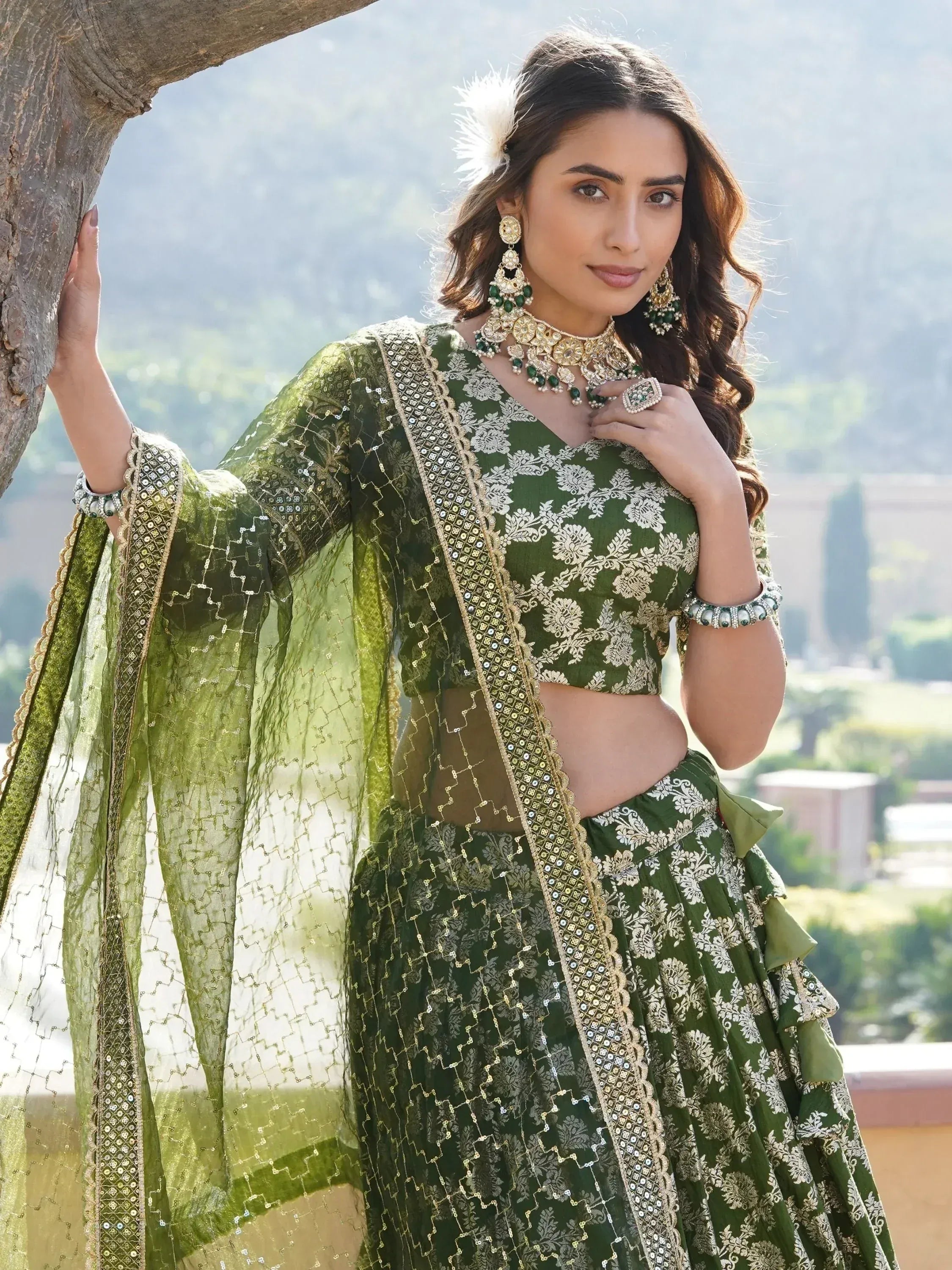 Elegant green embroidered lehenga choli with gold detailing and matching jewelry