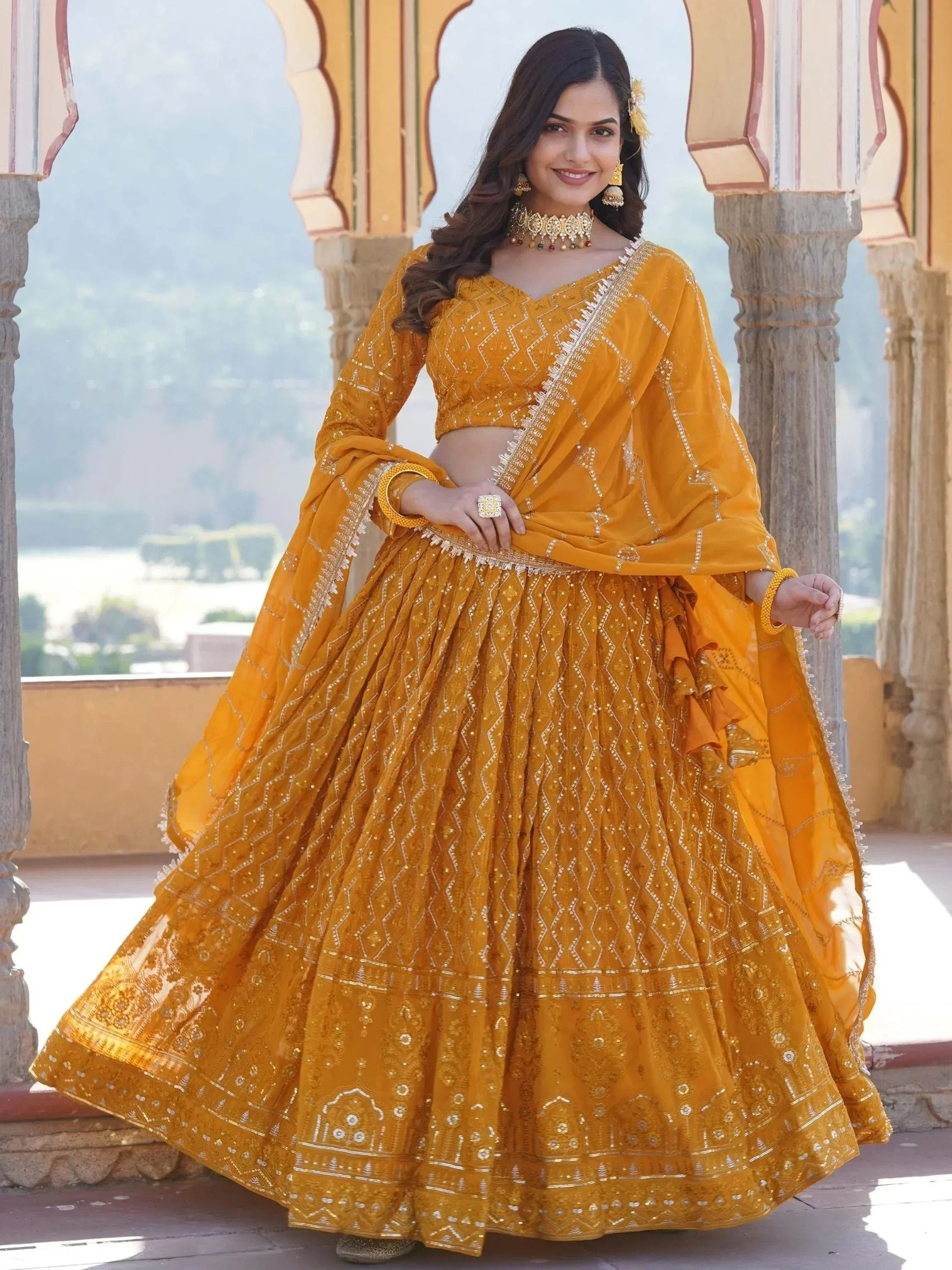 Mustard yellow designer lehenga choli with intricate embroidery and mirror work, perfect for Indian weddings and festive occasions.